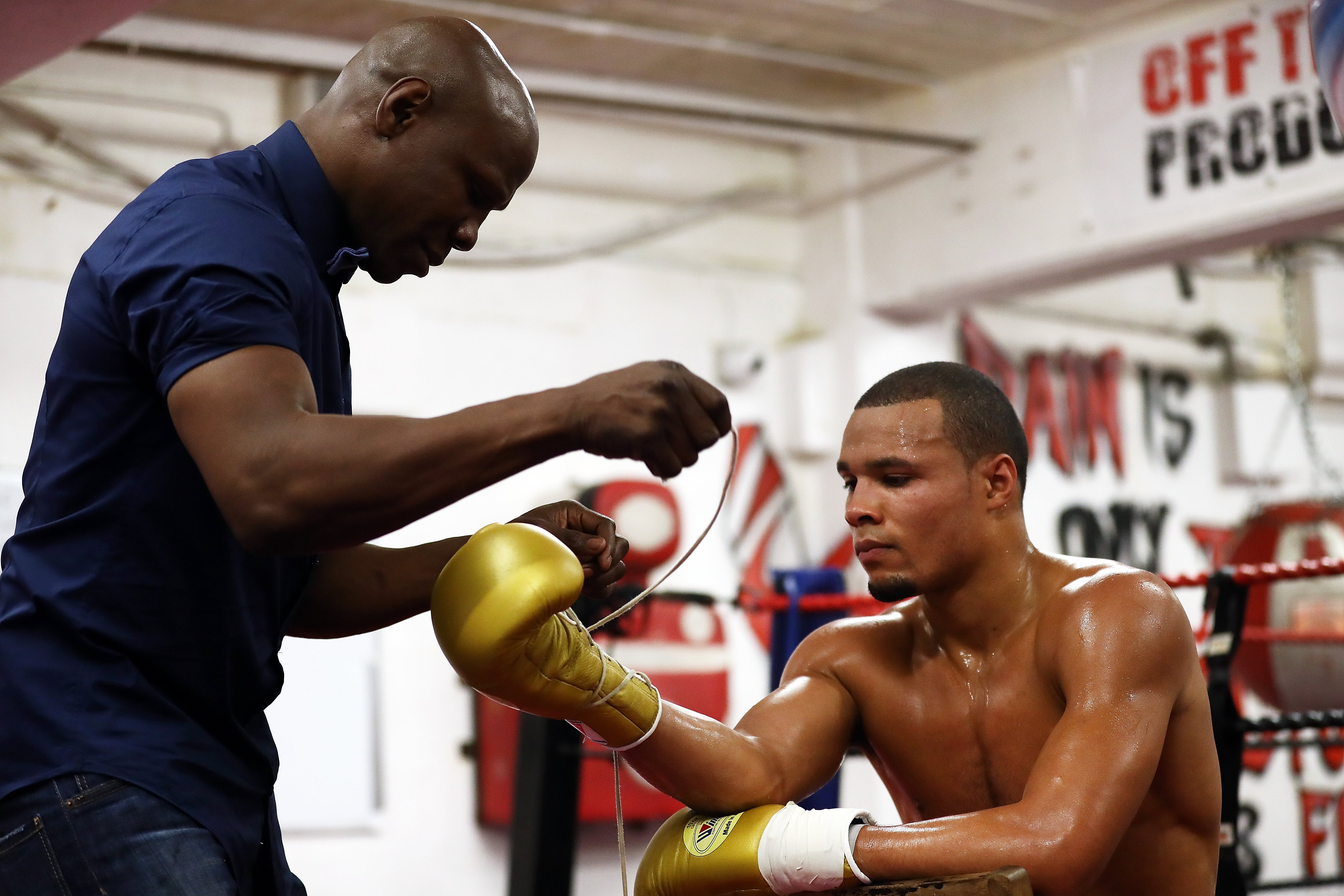 Eubank laces up his son Chris Jr’s gloves during a media workout in September 2017, in Hove