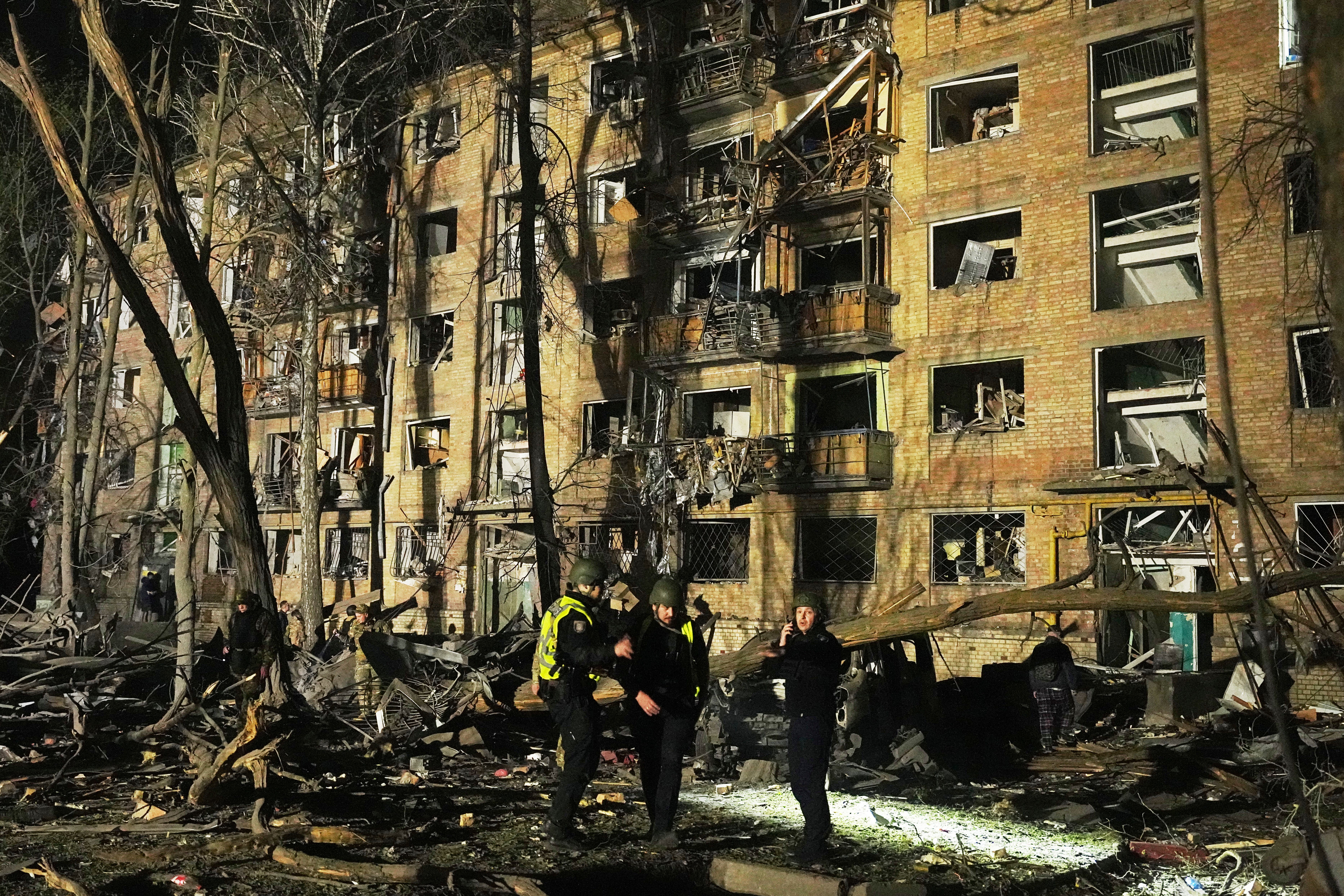 Ukrainian police officers stand near a damaged building after a Russian ballistic missile attack in Kyiv (AP Photo/Efrem Lukatsky)