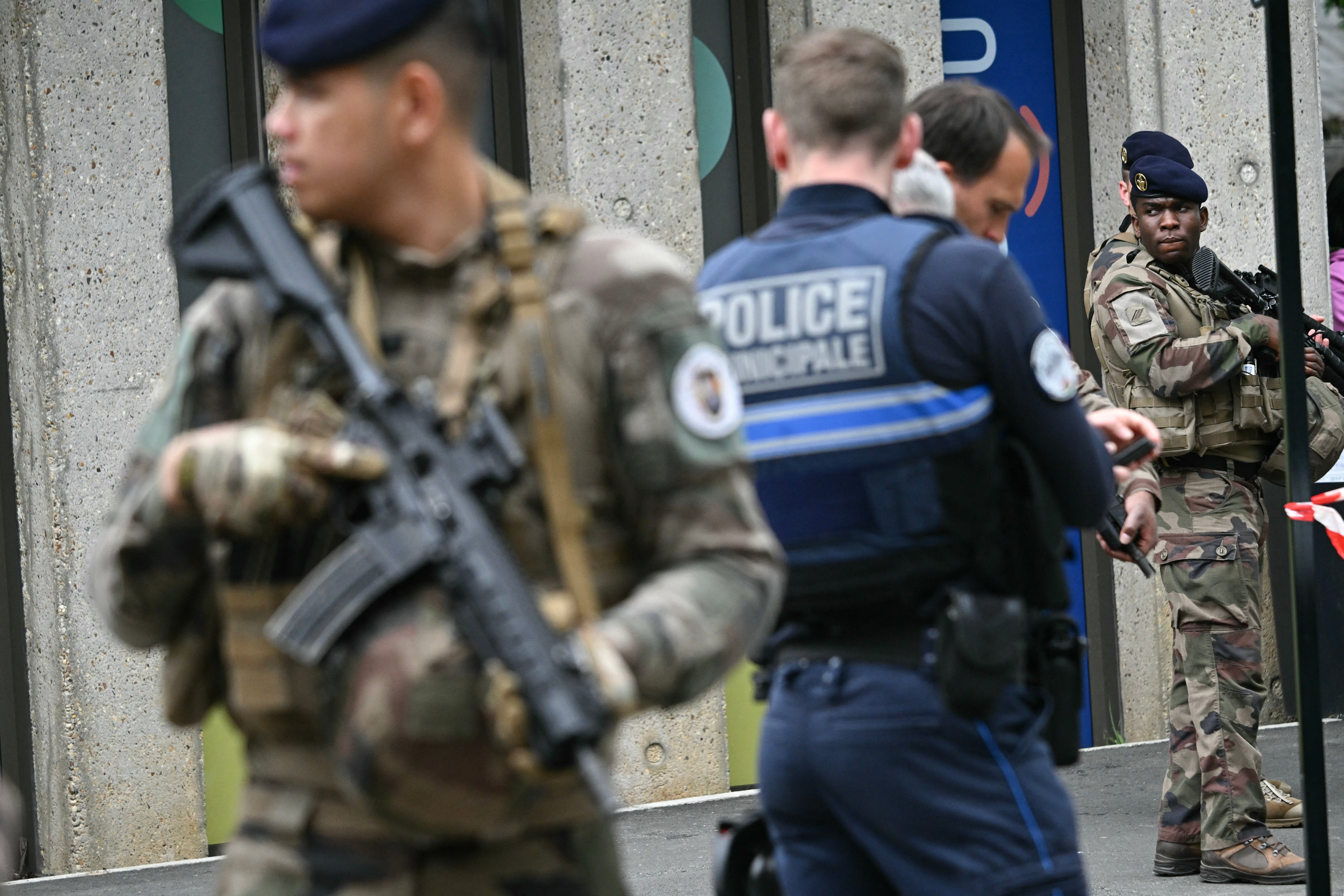 French military and police officers stand outside the high school Notre-Dame de Toutes-Aides where a student allegedly killed another teen and wounded three others in a knife attack