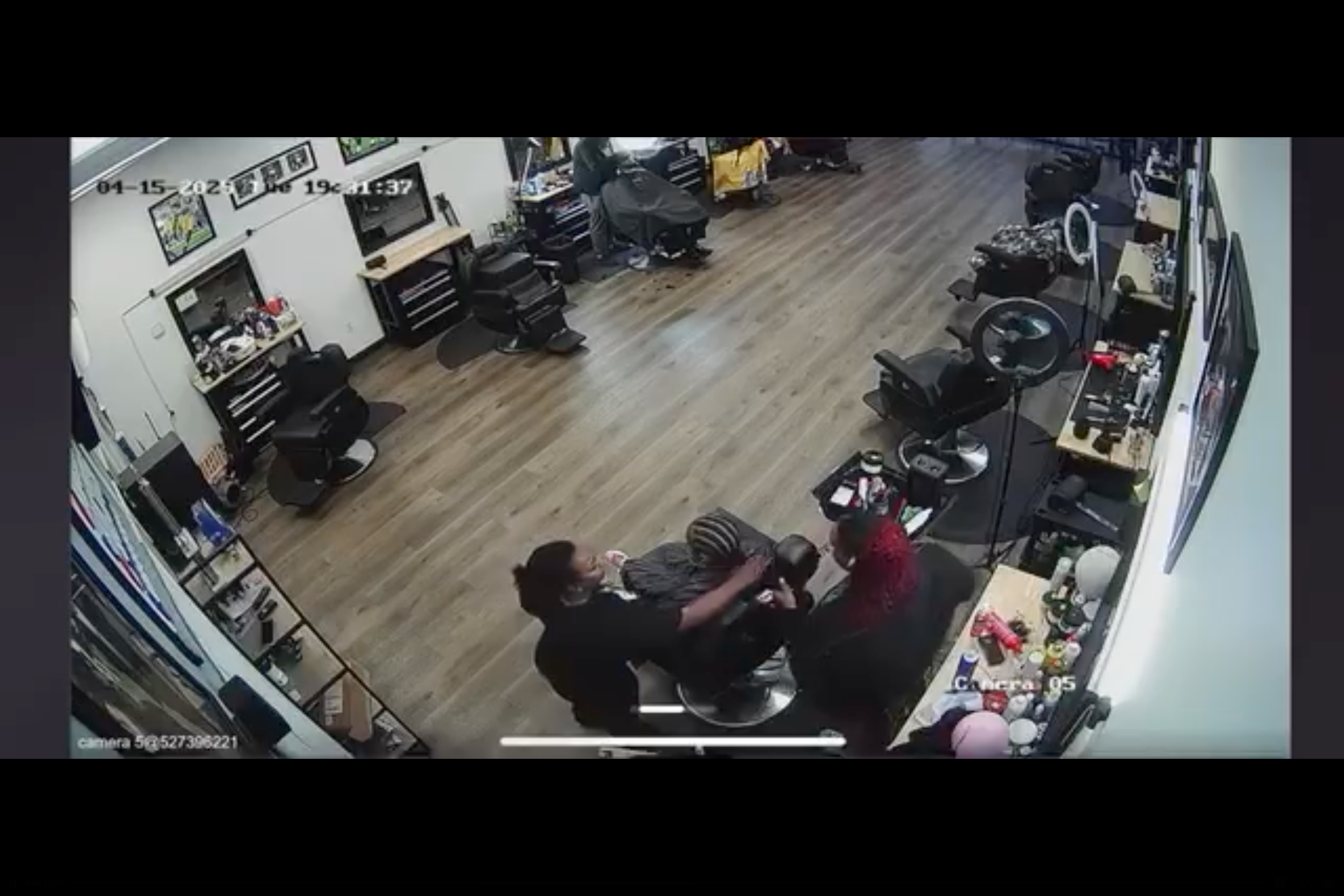 The mother grabs her daughter's braids as the hairdresser continues to hold onto them