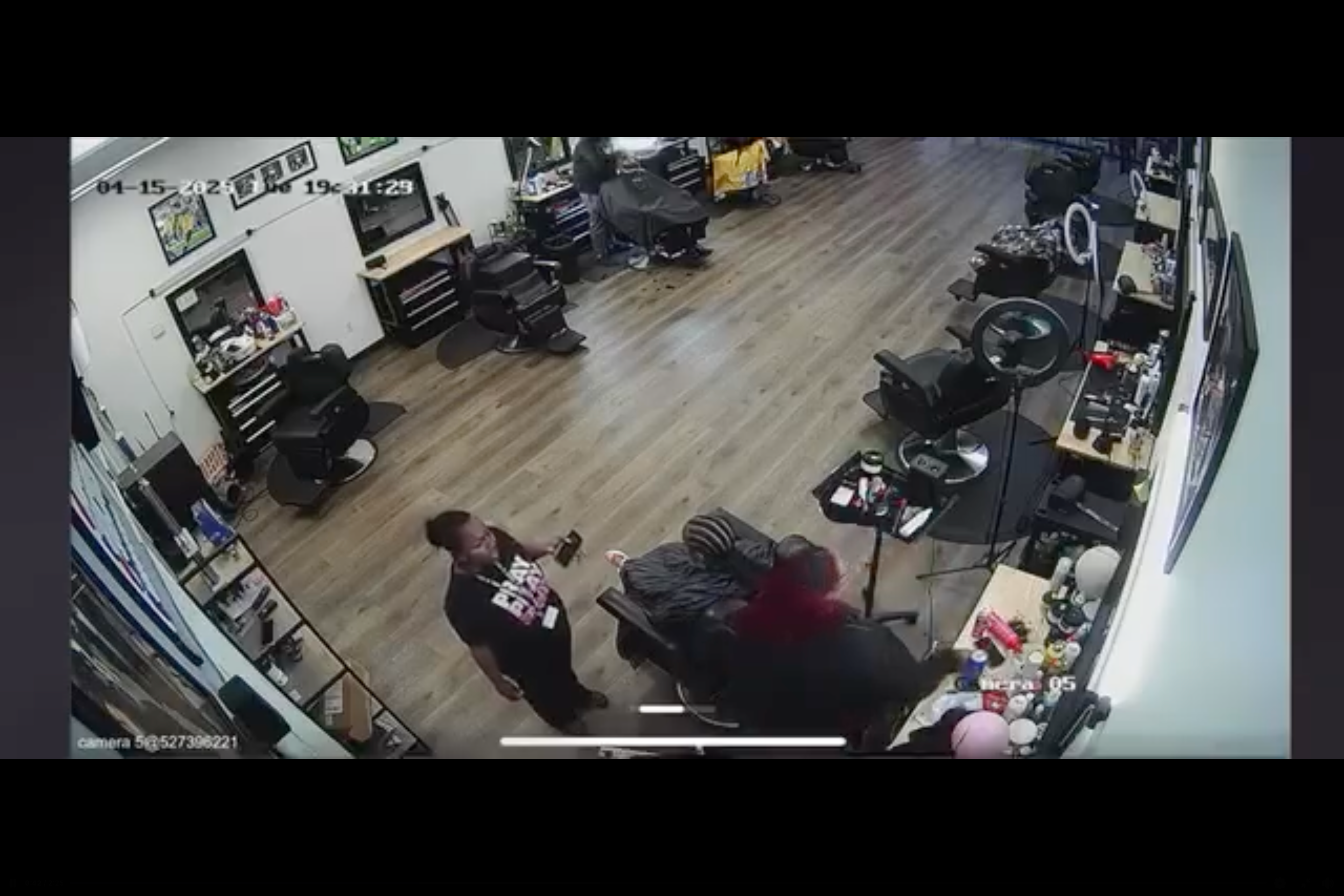 The hairdresser turns around and picks up her scissors from her station