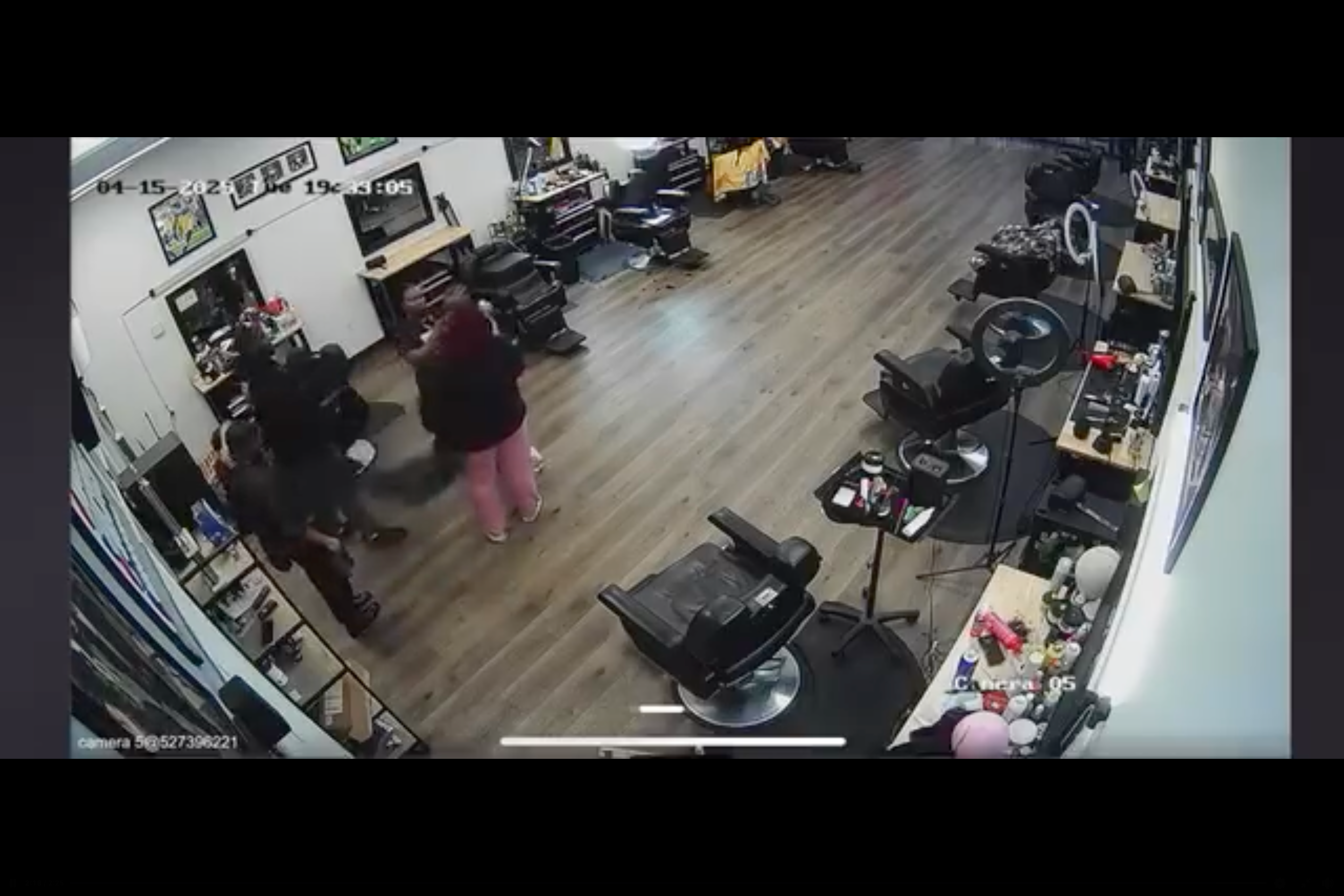 The huddle breaks up and the hair stylist takes the cape off of the child