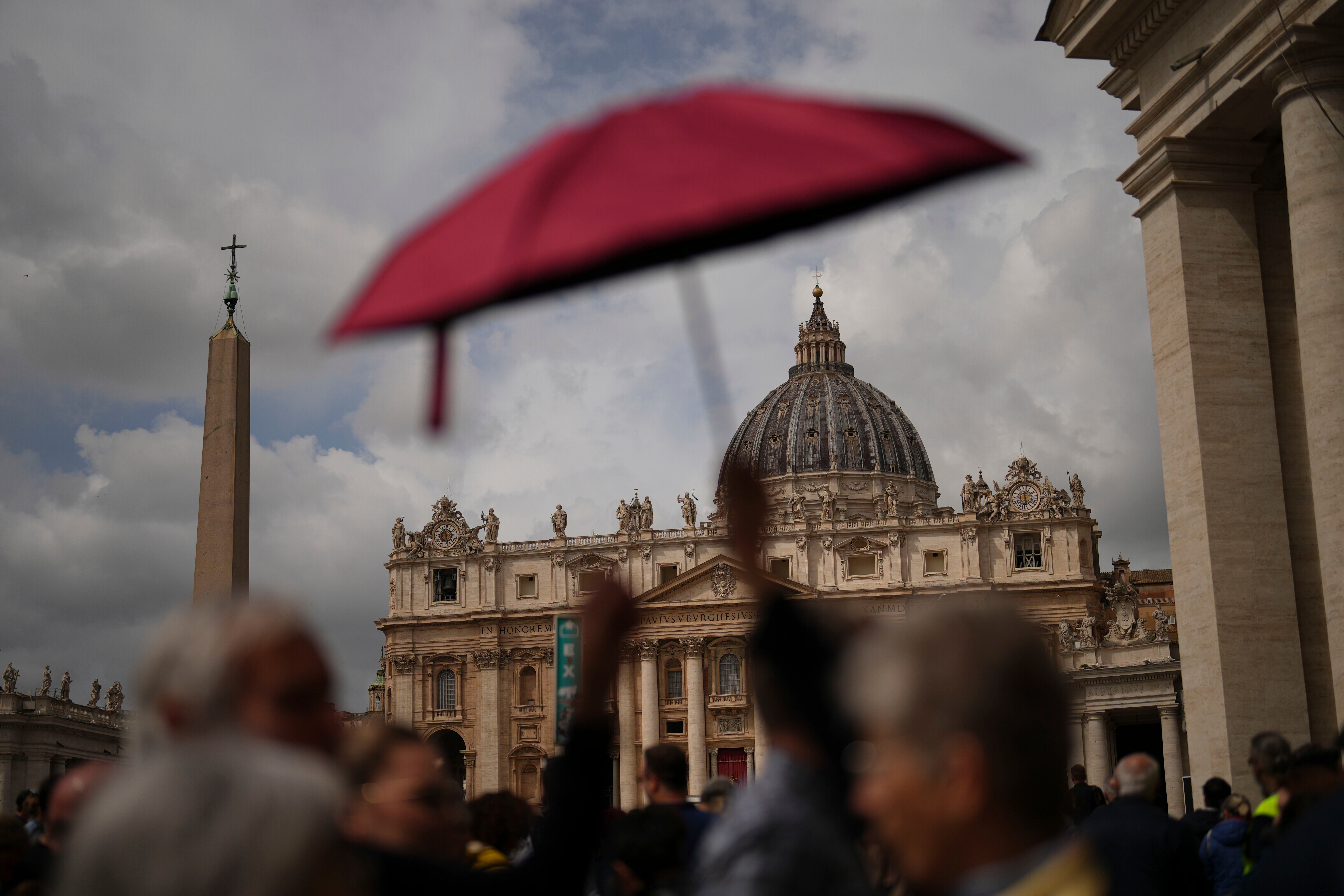 People wait in line under the rain to enter St Peter’s Basilica to view Pope Francis lying in state, at the Vatican, Thursday, 24 April 2025