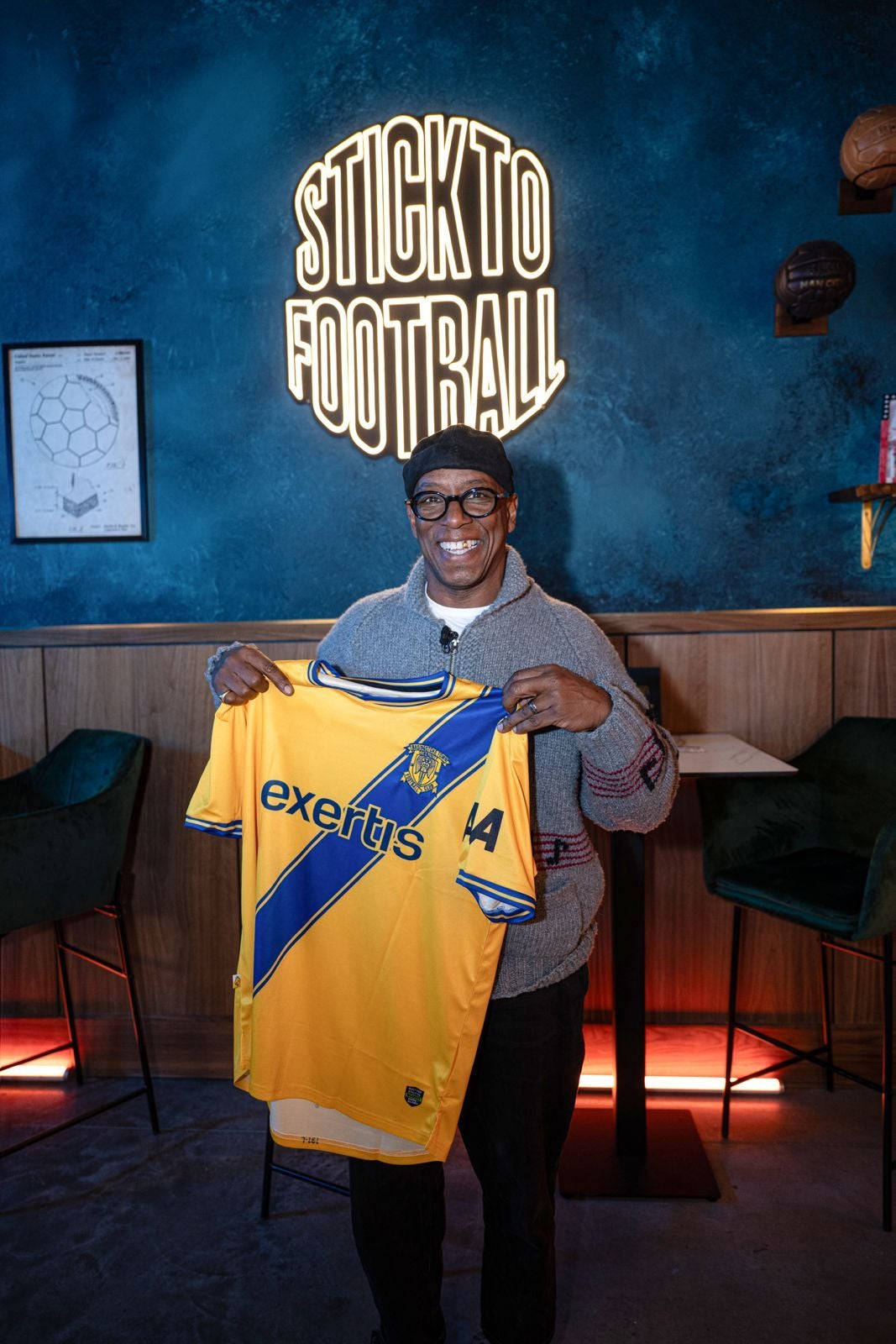 Arsenal legend Ian Wright with a Basingstoke Town football club kit whose match shirts have been redesigned to feature a seat belt motif as part of a road safety campaign