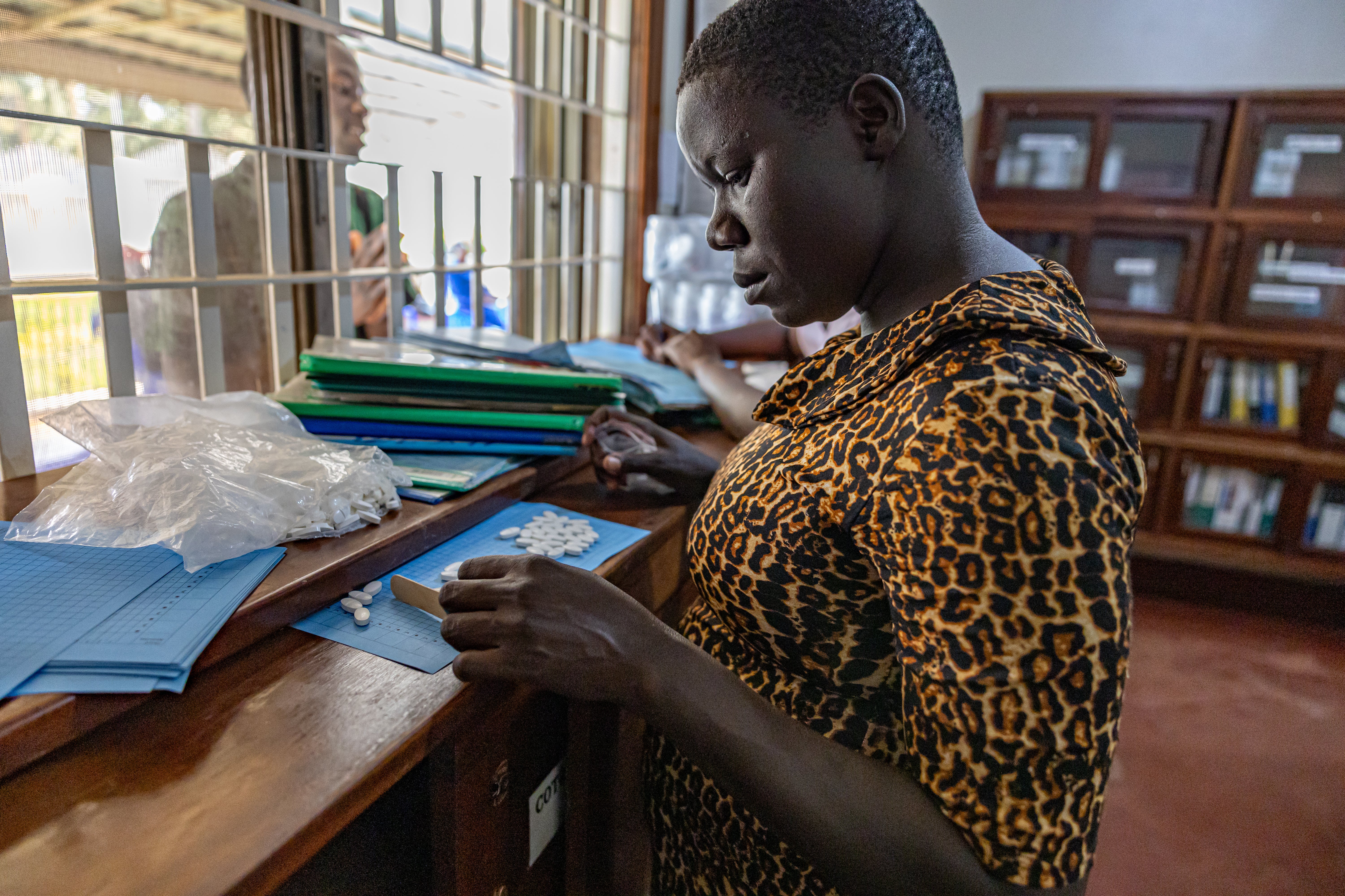 A healthcare worker in the Family Hope Clinic in Uganda administers HIV medication