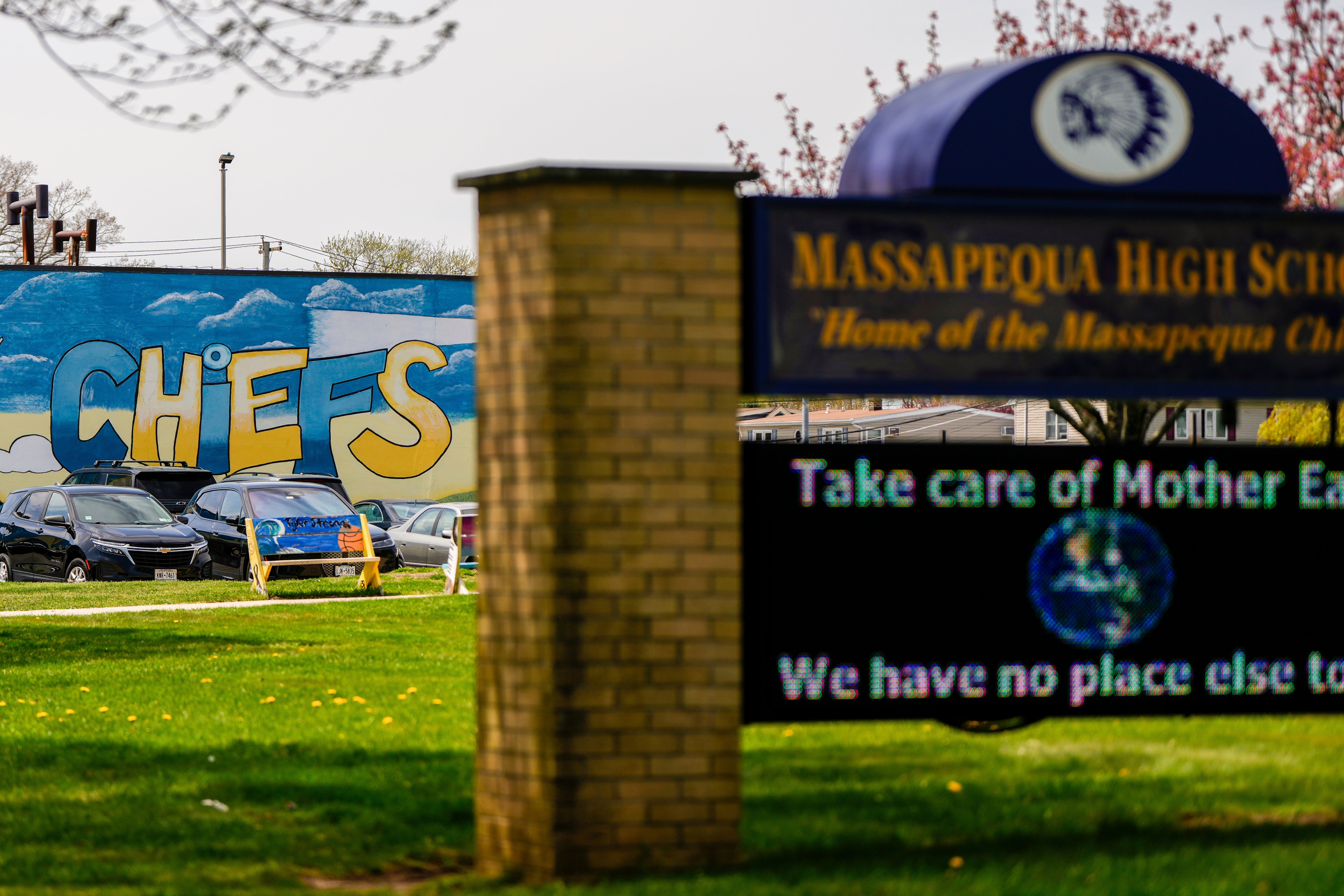 A marquee outside the Massapequa High School is backdropped by a "Chiefs" mascot mural, in Massapequa, N.Y., Friday, April 25, 2025. (AP Photo/Julia Demaree Nikhinson)