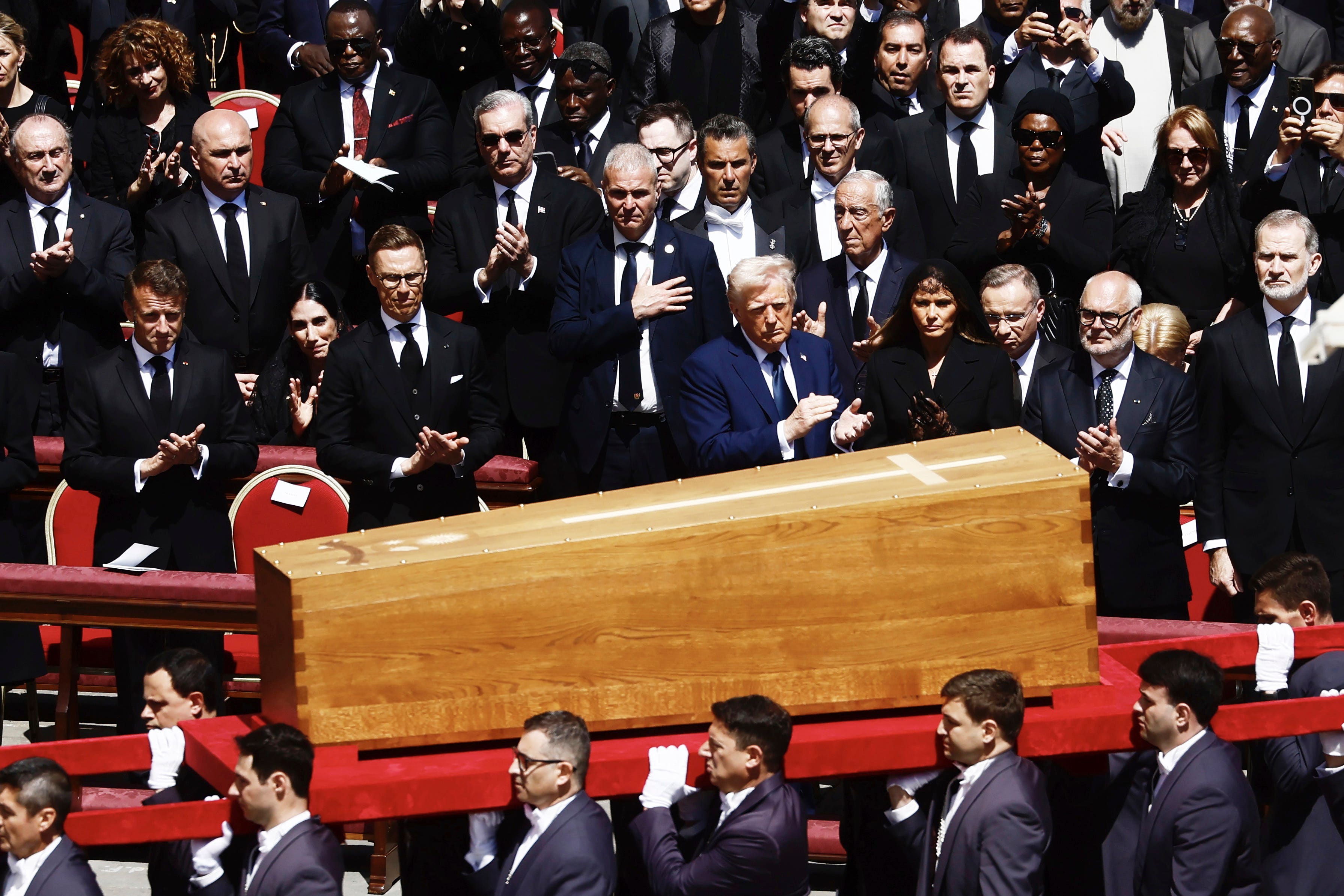 The coffin of Pope Francis is carried in front of dignitaries, including US President Donald Trump, centre, and French President Emmanuel Macron (Cecilia Fabiano/PA)