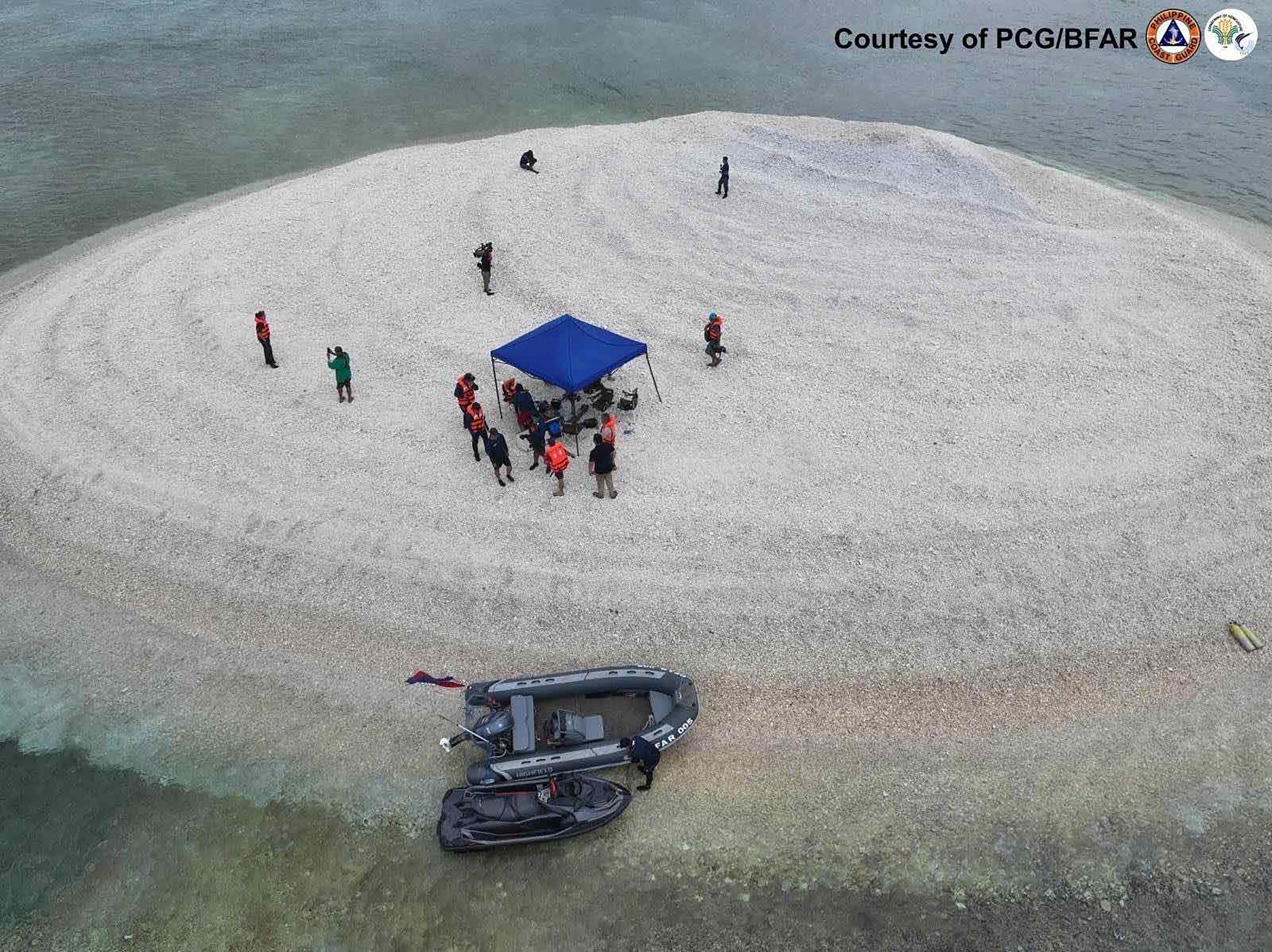 File image from 21 March, 2024 shows Philippine scientists inspecting Sandy Cay reef, near the Philippine-held Thitu Island, in Spratly Islands, in disputed waters of the South China Sea. The Chinese coast guard seized control of a disputed reef near a major Philippine military outpost in the South China Sea, according to state media