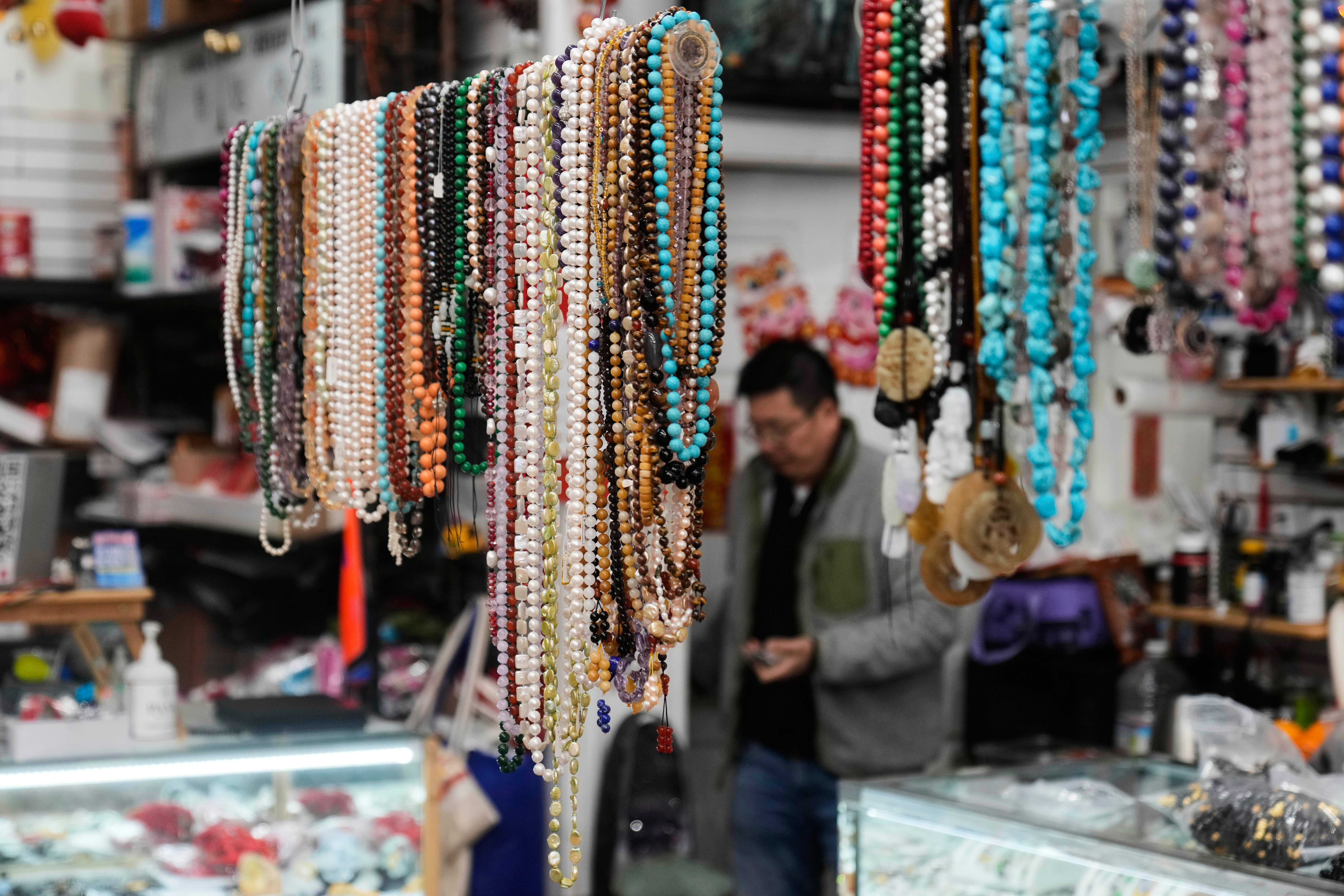 Lyndon Lin, owner CK Color Stone and Beads, walks behind beads from China and other Asian countries displayed at his shop in San Francisco’s Chinatown on 18 April 2025