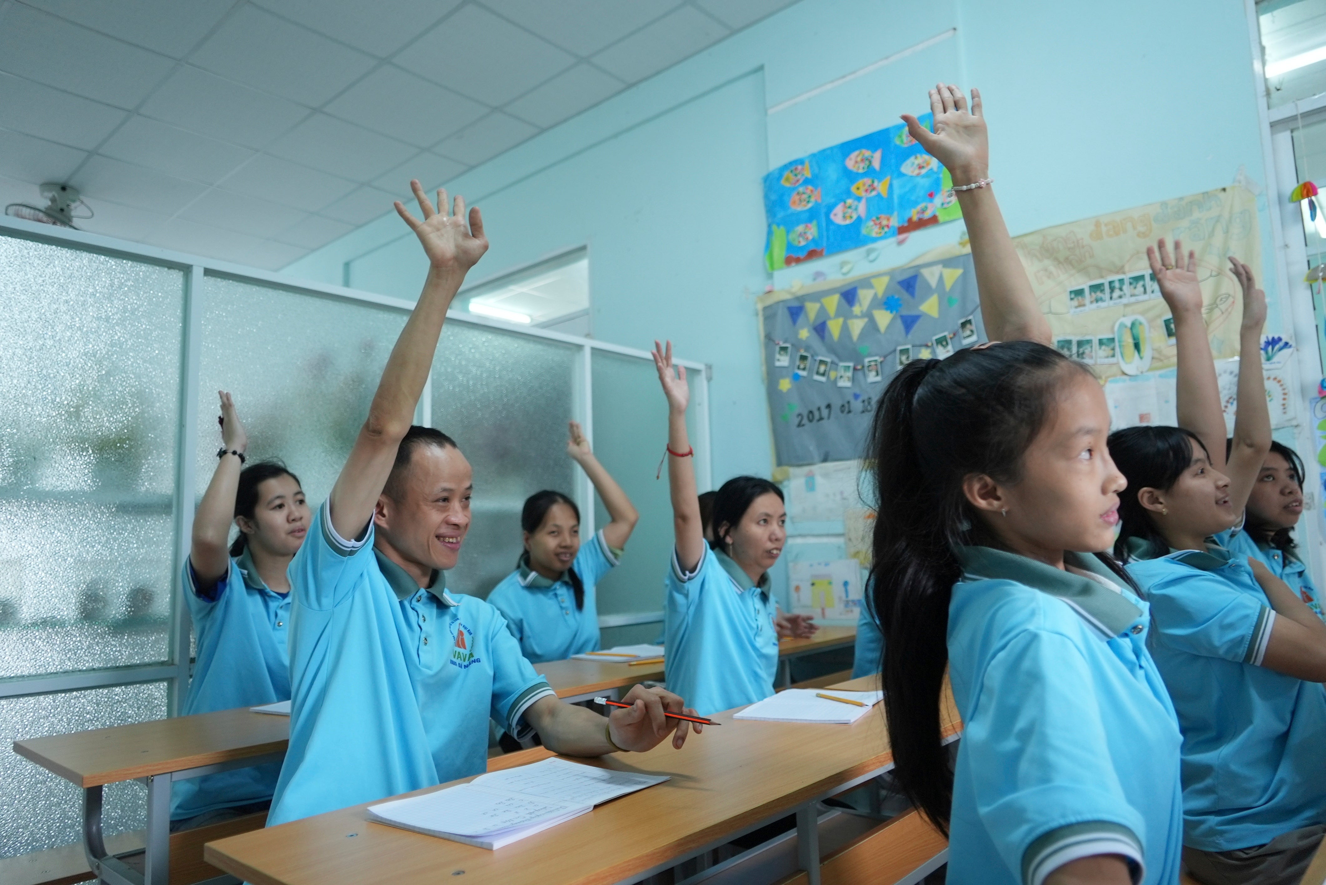 Nguyen Thanh Hai, center, raises his hand to answer a question