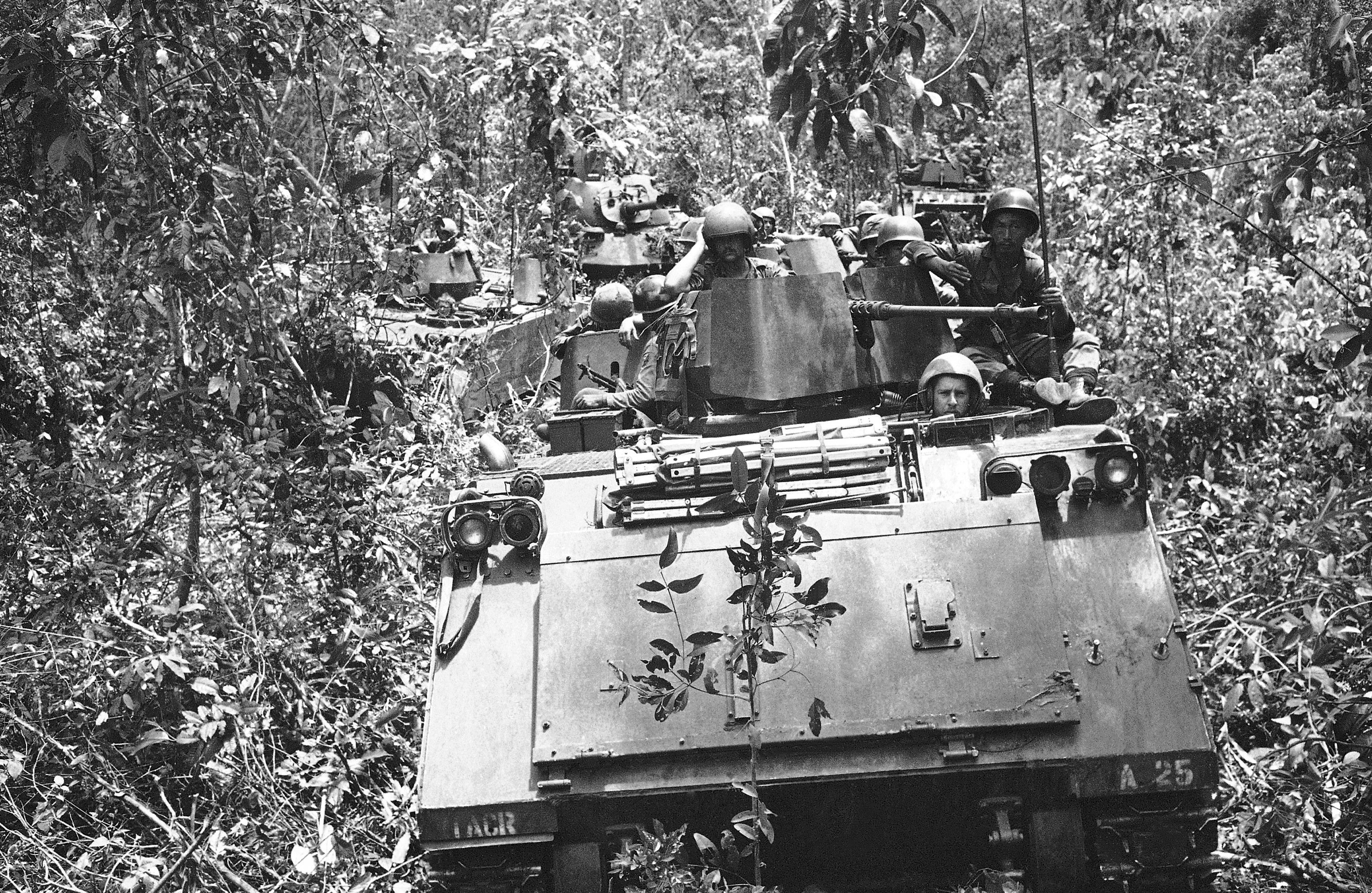 Armored personnel carriers with tank support move through dense underbrush with a payload of South Vietnamese infantrymen and U.S. cavalrymen in 1969