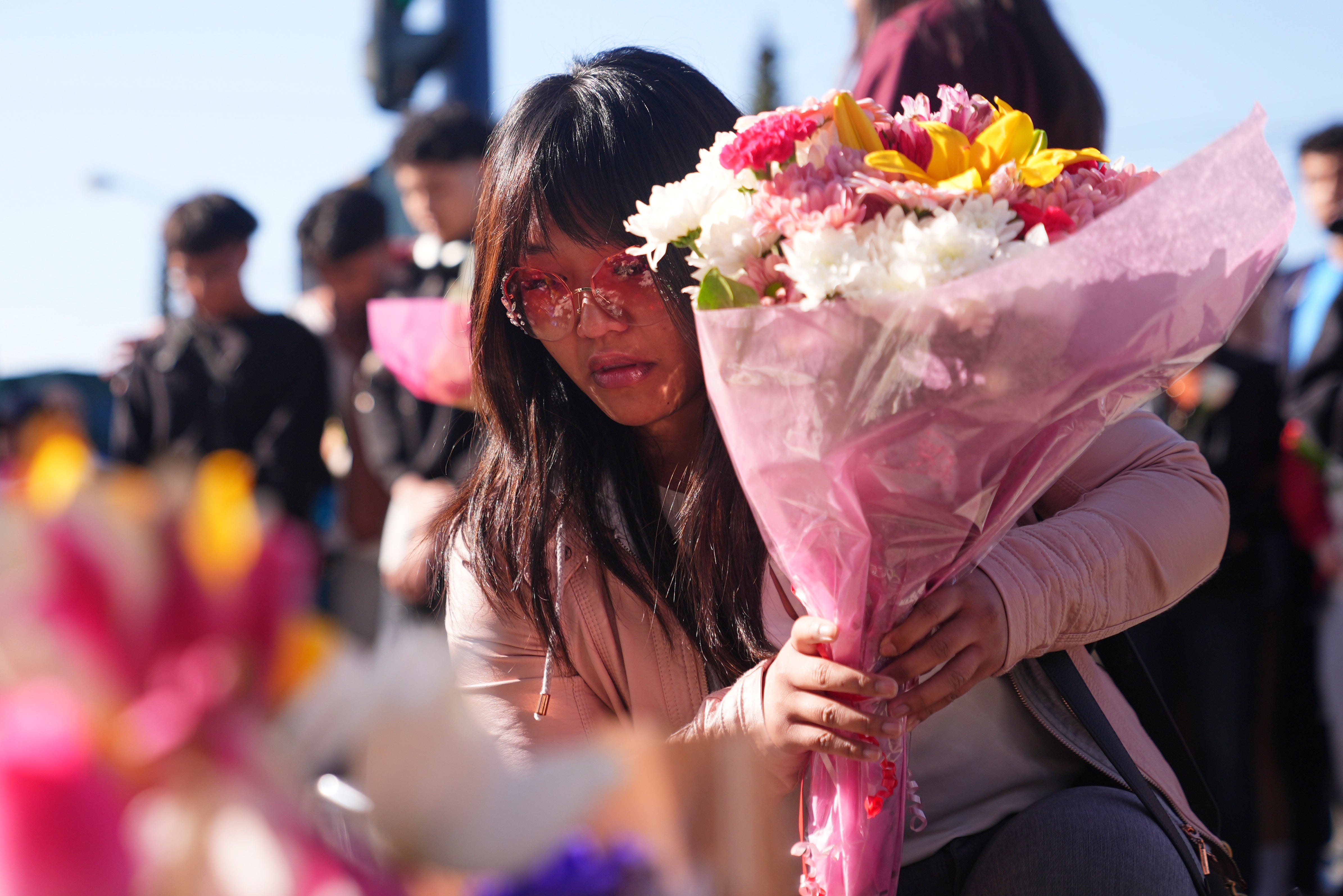 A woman places flowers at a memorial after a vehicle drove into a crowd during a Filipino heritage festival in Vancouver on 27 April 2025