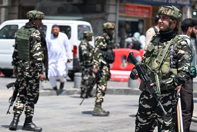 <p>Indian paramilitary troopers stand guard in a market area in Srinagar</p>