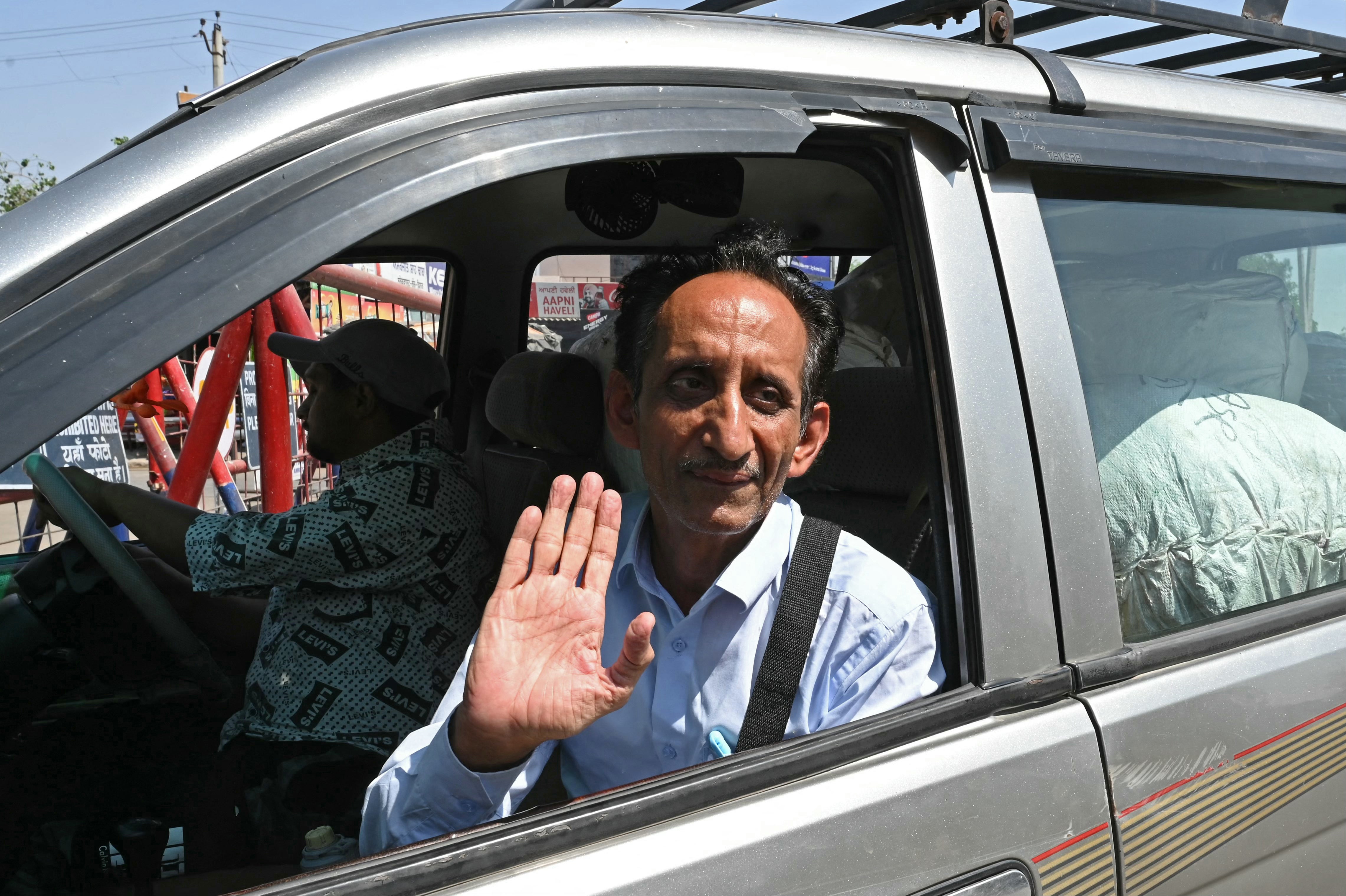 A Pakistani man waves goodbye as he returns home from India at the Wagah border post, about 35km from the northern city of Amritsar, on 28 April 2025