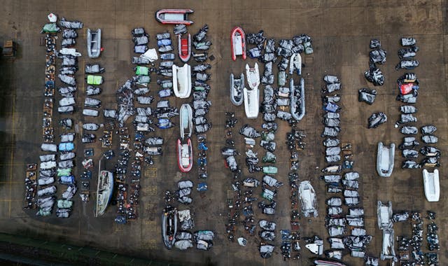 <p>Confiscated small boats and outboard motors used to cross the Channel from France at a warehouse facility in Dover, Kent</p>