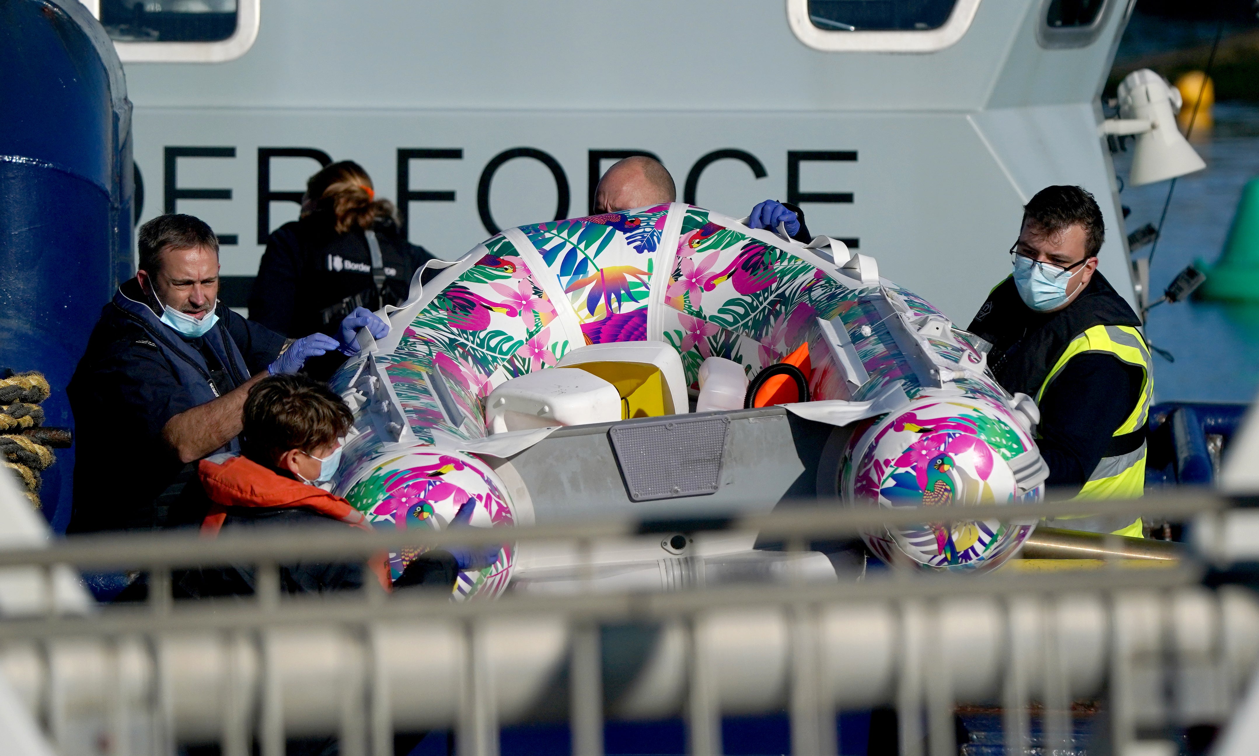 Border Force officers carry a small boat from a Border Force vessel
