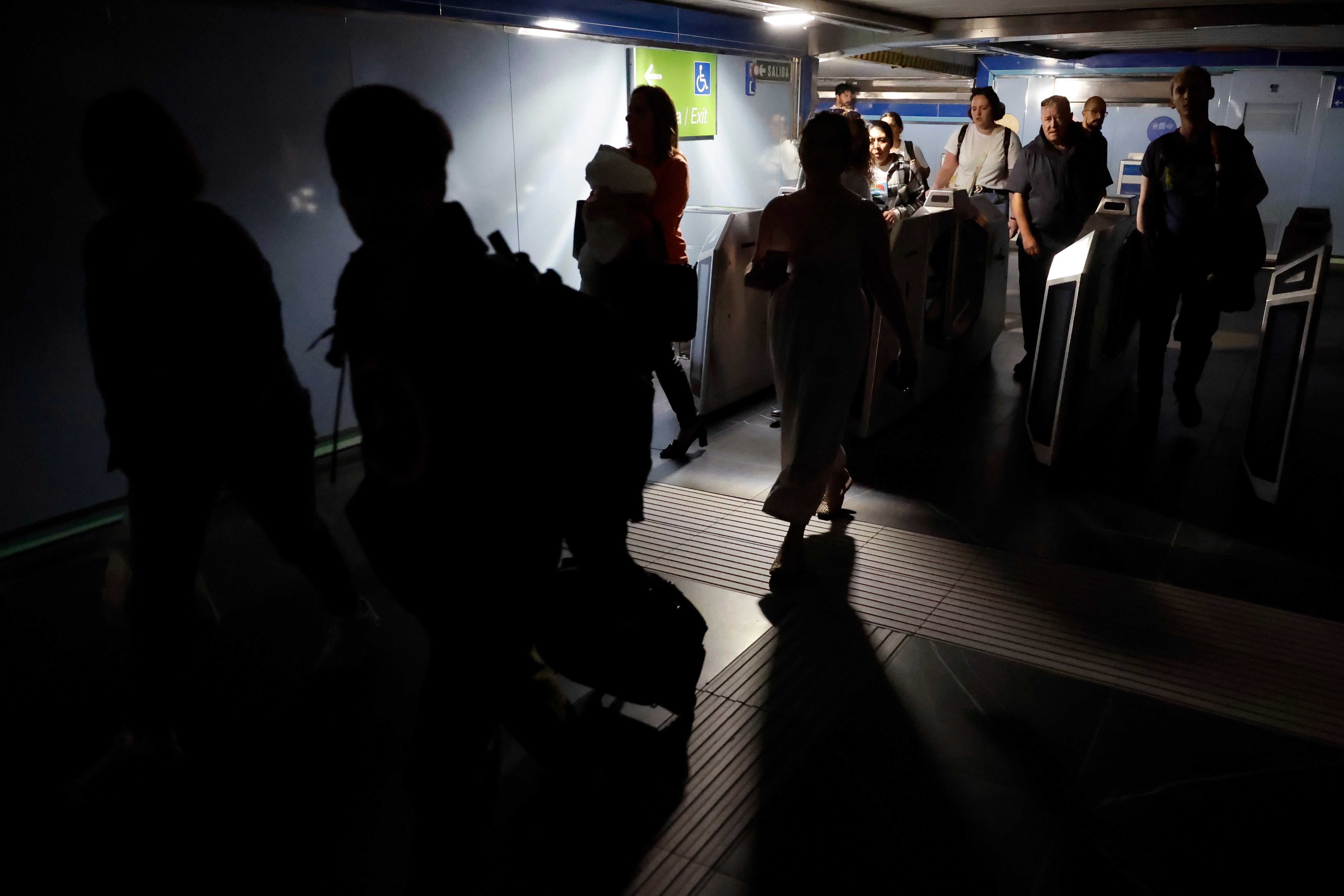 Commuters leave a subway station after a blackout in Madrid