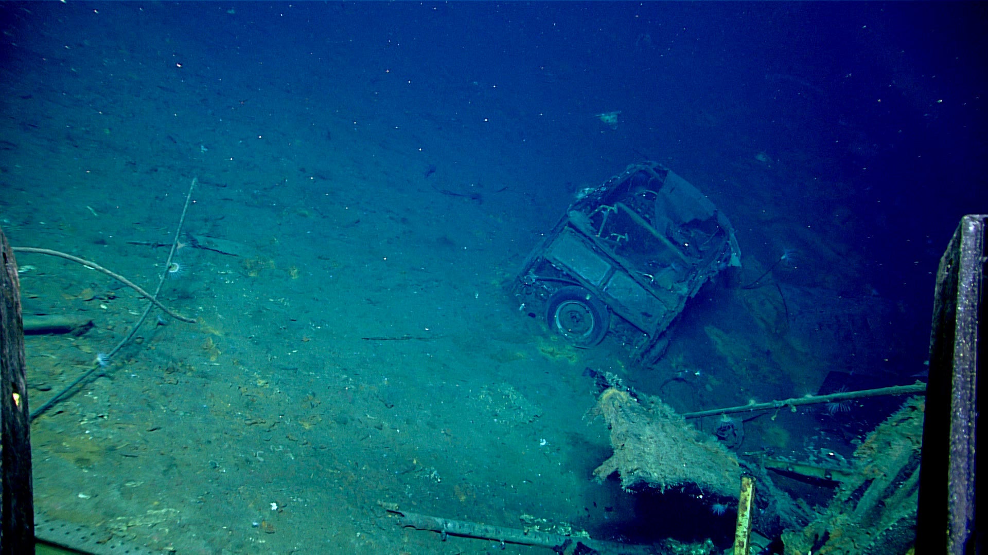This image of an automobile on USS Yorktown first discovered during the April 19 dive and further explored on April 20 shows the car's boxy shape, canvas top, chrome bumper, and spare tire on the back