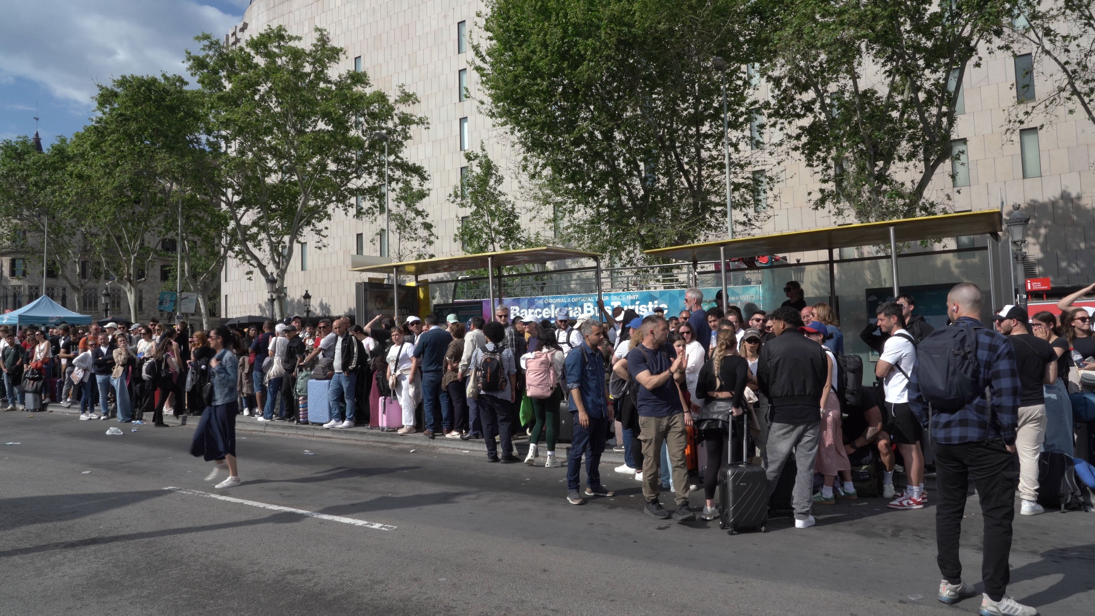 People wait for the bus to the airport in Barcelona