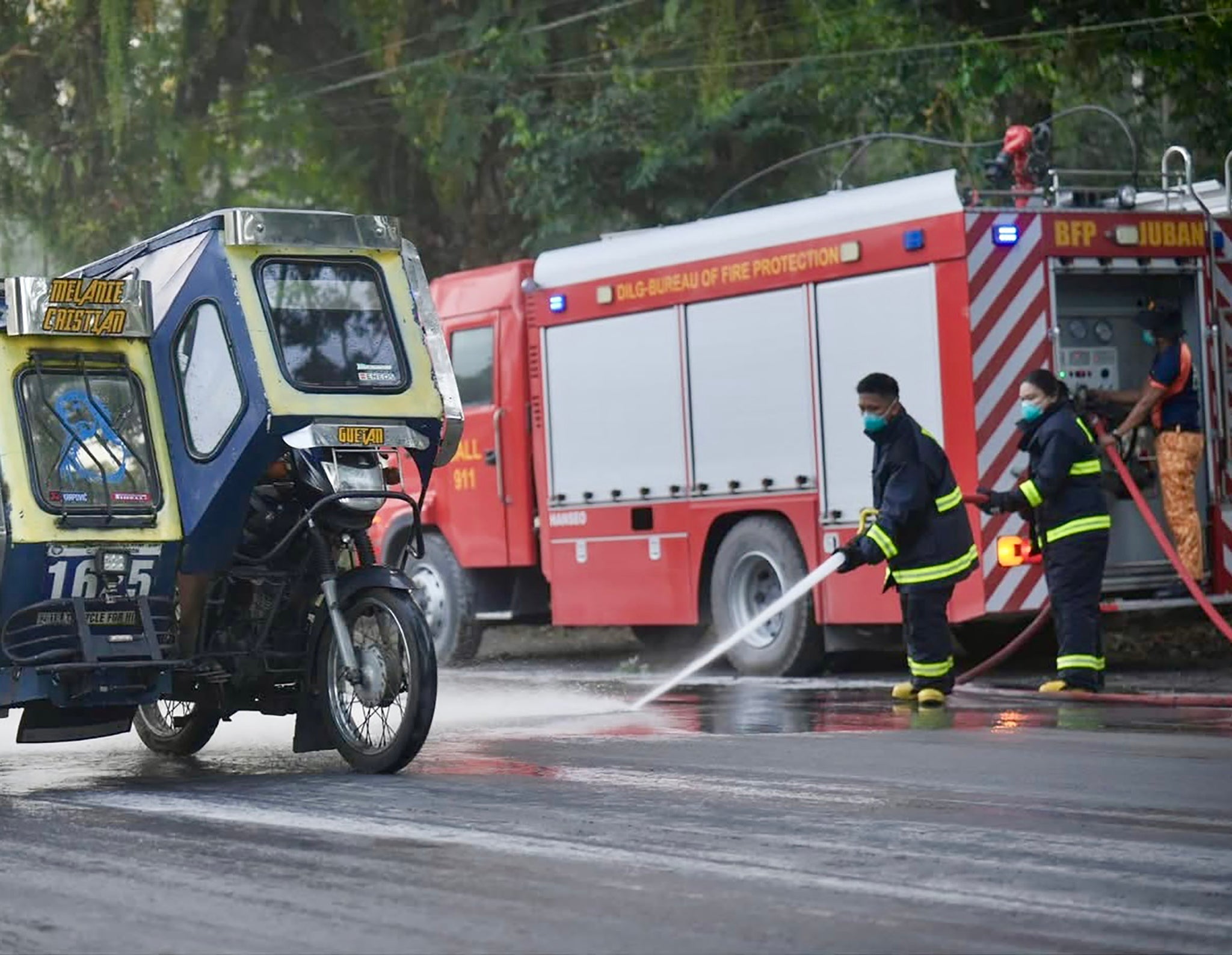 A handout photo made available by the Sorsogon Provincial Information Office (SPIO) shows firemen hosing a road covered with volcanic ash from the Bulusan volcano in the town of Juban, Sorsogon province, Philippines, 28 April 2025