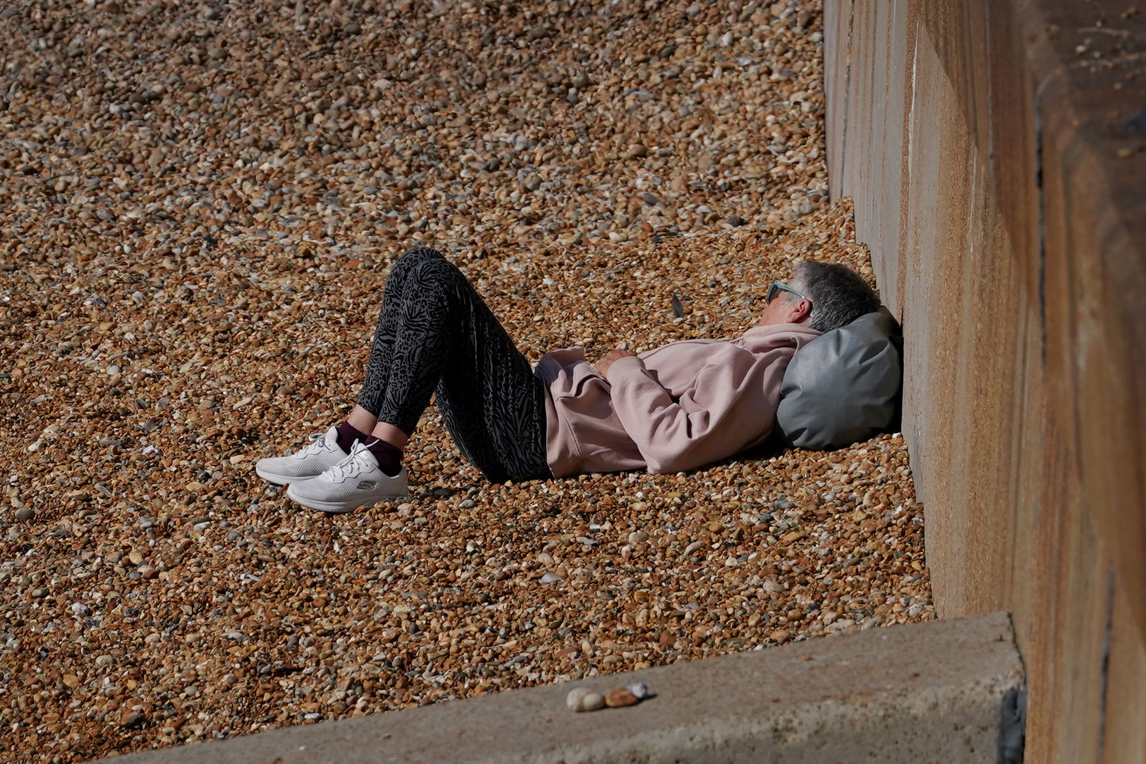 A woman relaxes in the morning sunshine on the beach in Dover (Gareth Fuller/PA)