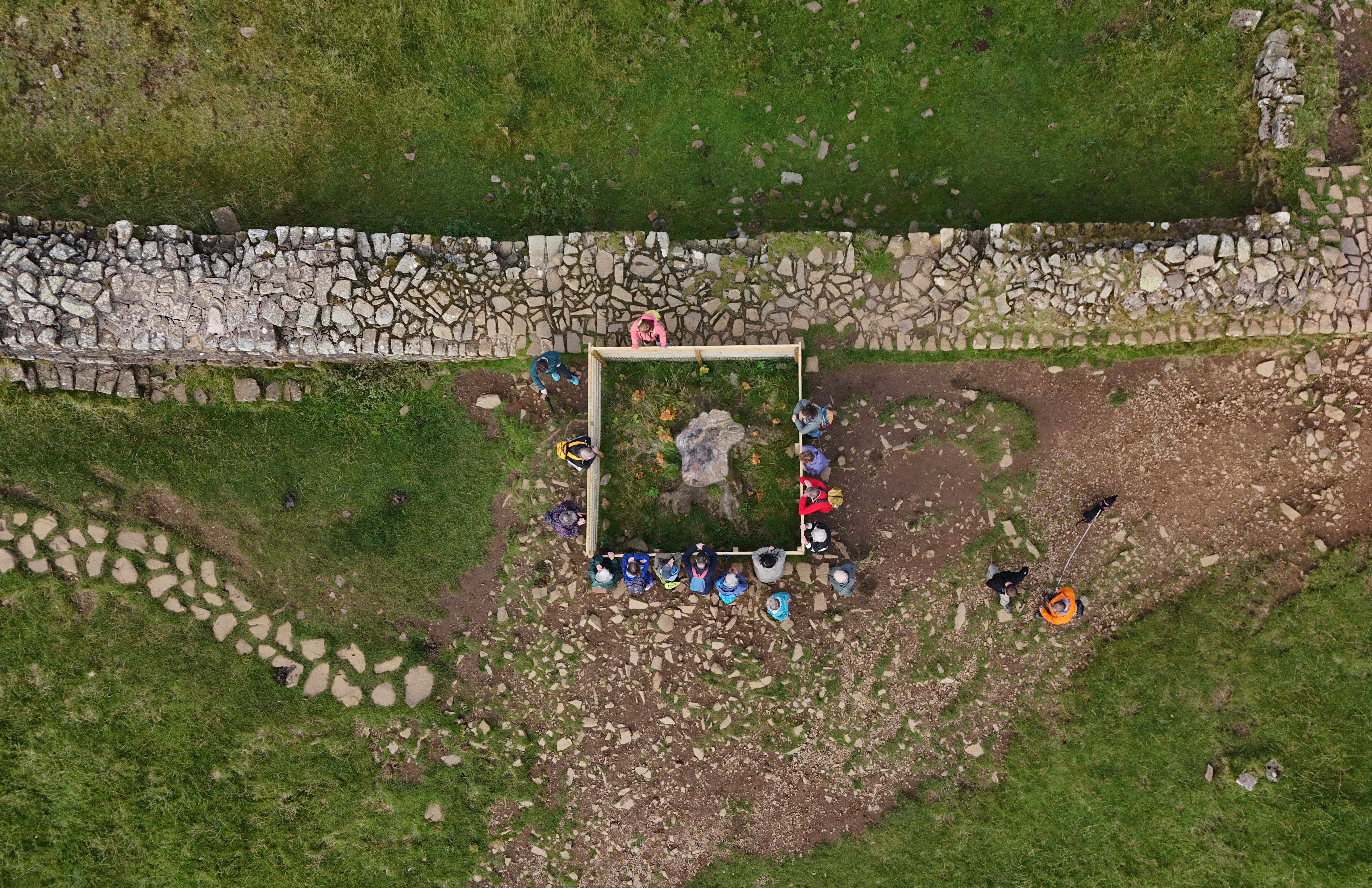 People gather around the stump of the Sycamore Gap tree in Northumberland (PA)