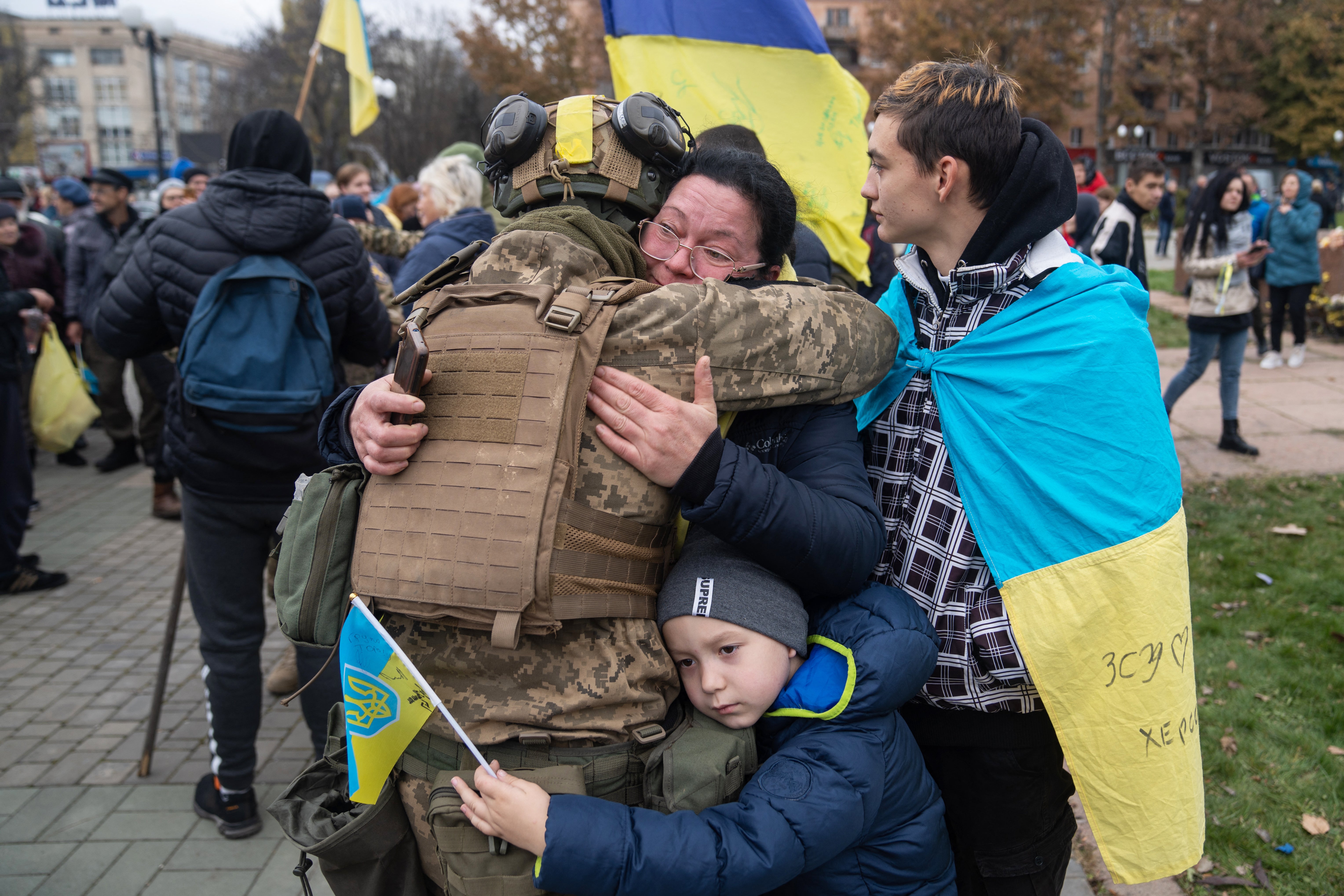 Local residents hug a Ukrainian soldier as they celebrate the liberation of Kherson, on 13 November 2022
