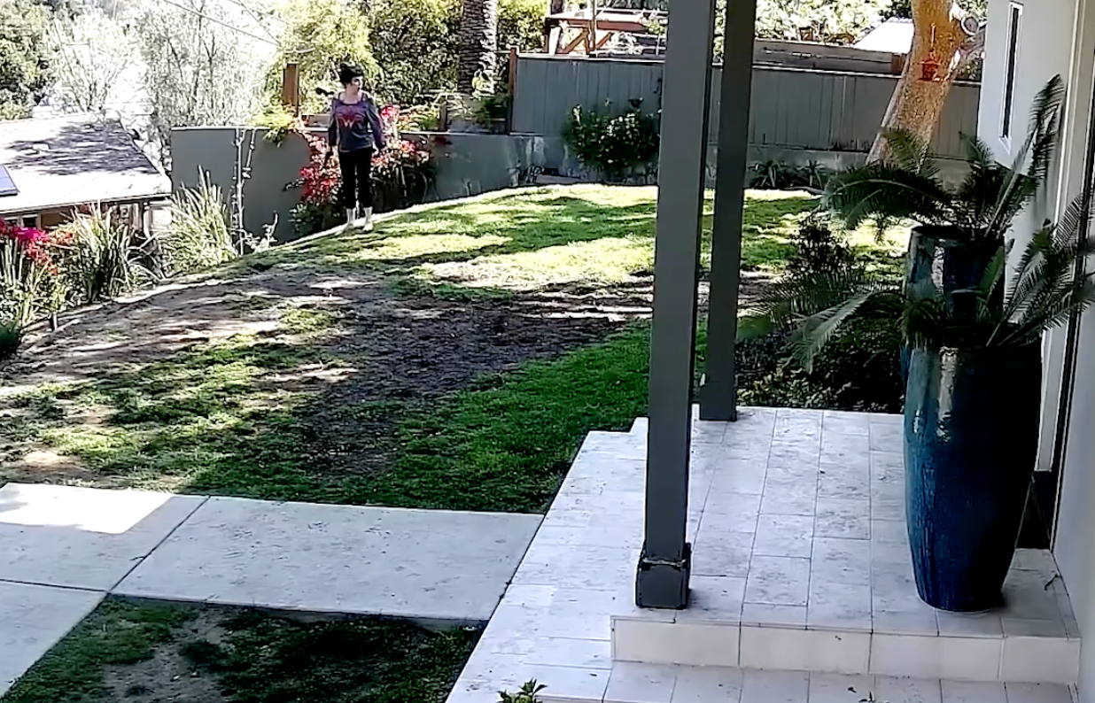 Jessica Lauren walks through her yard with a gun. Police later recovered a 9mm handgun in her home