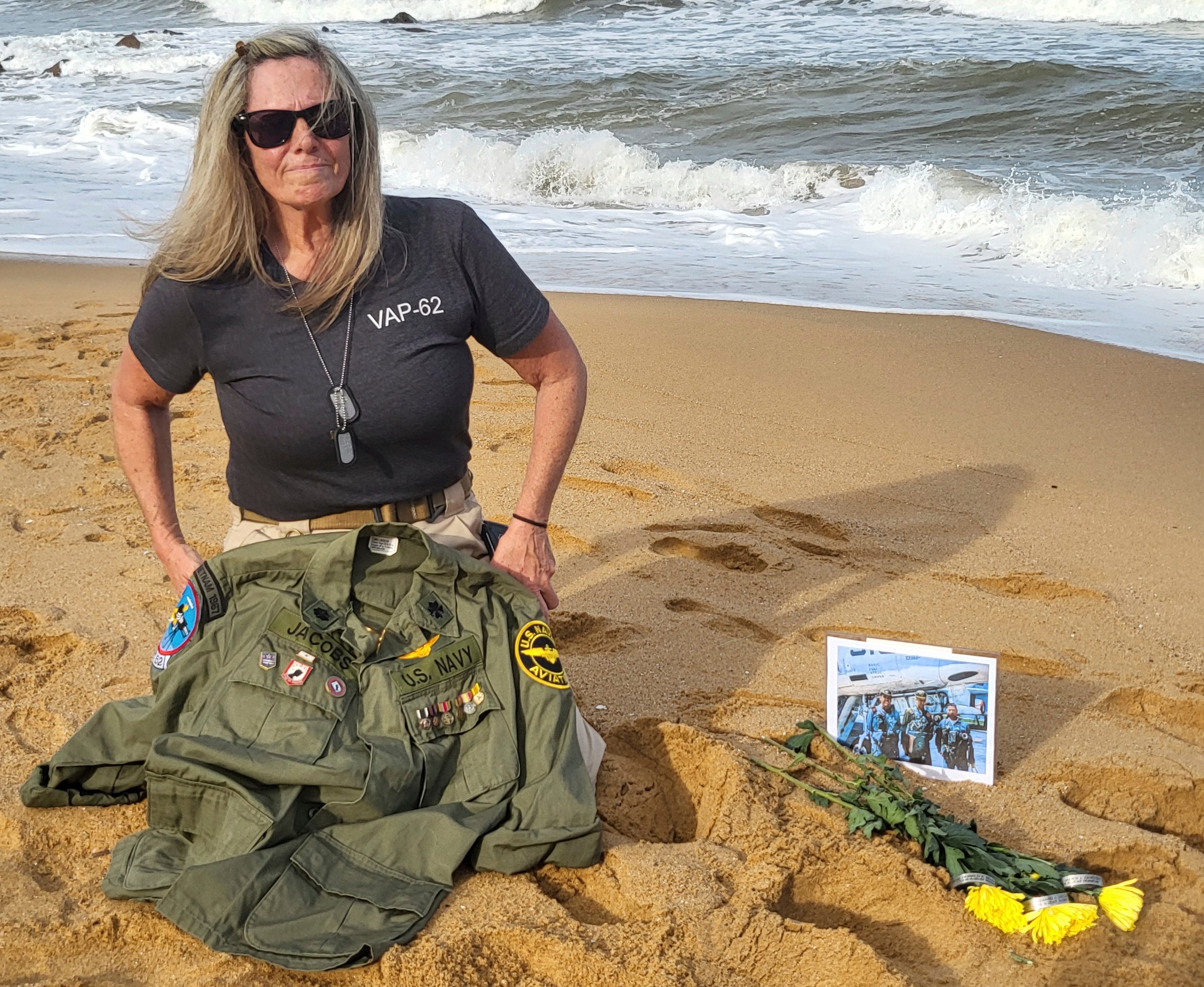 This photo provided by Jeanie Jacobs Huffman shows her on the beach in June 2024, two miles away from where her father's plane and crew were discovered in 70 feet of water, in Thanh Hoa Province, Vietnam. (Dave Huffman/Jeanie Jacobs Huffman via AP)