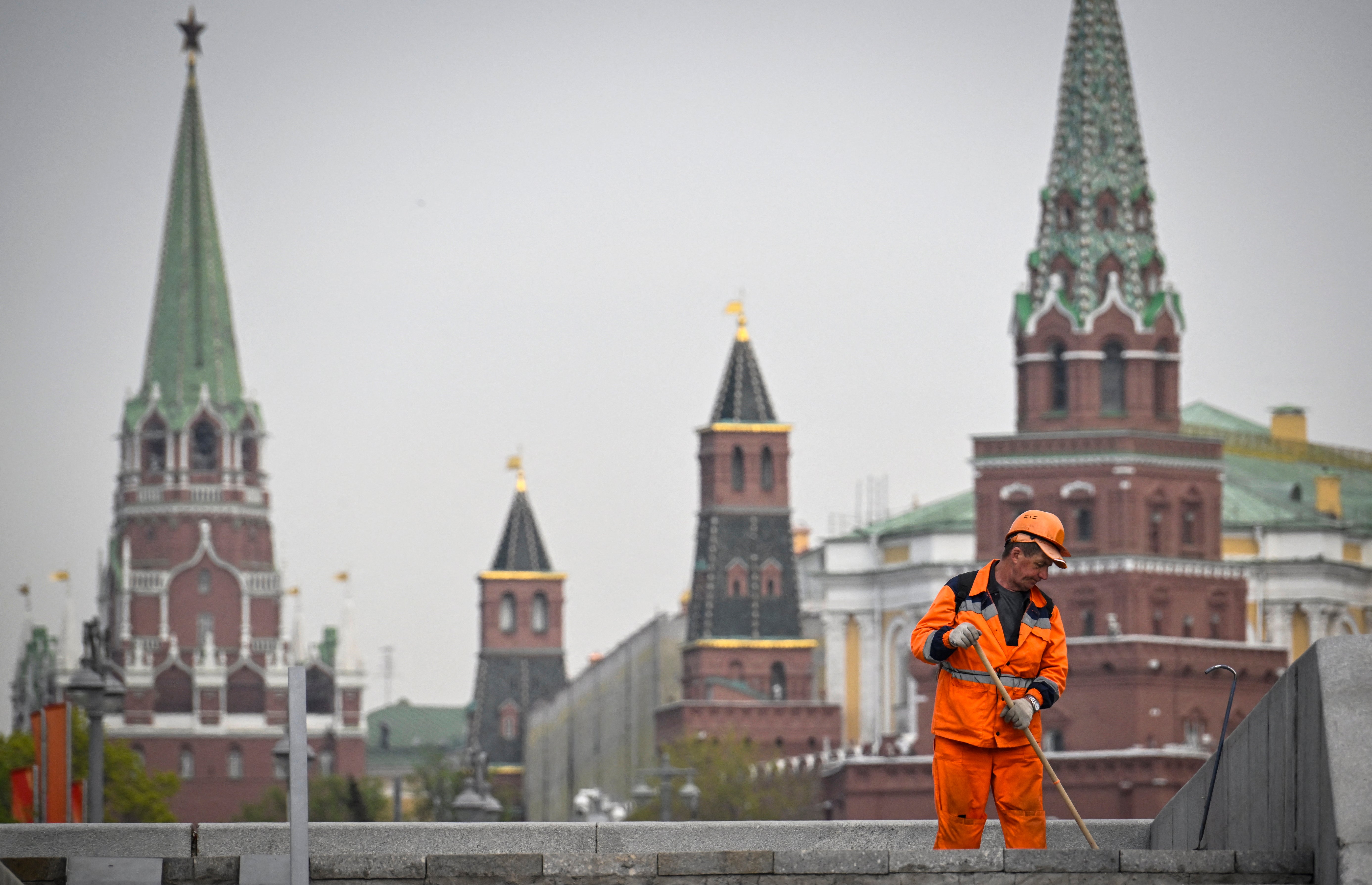 A municipal worker cleans a street in front of the Kremlin in Moscow on April 23, 2025