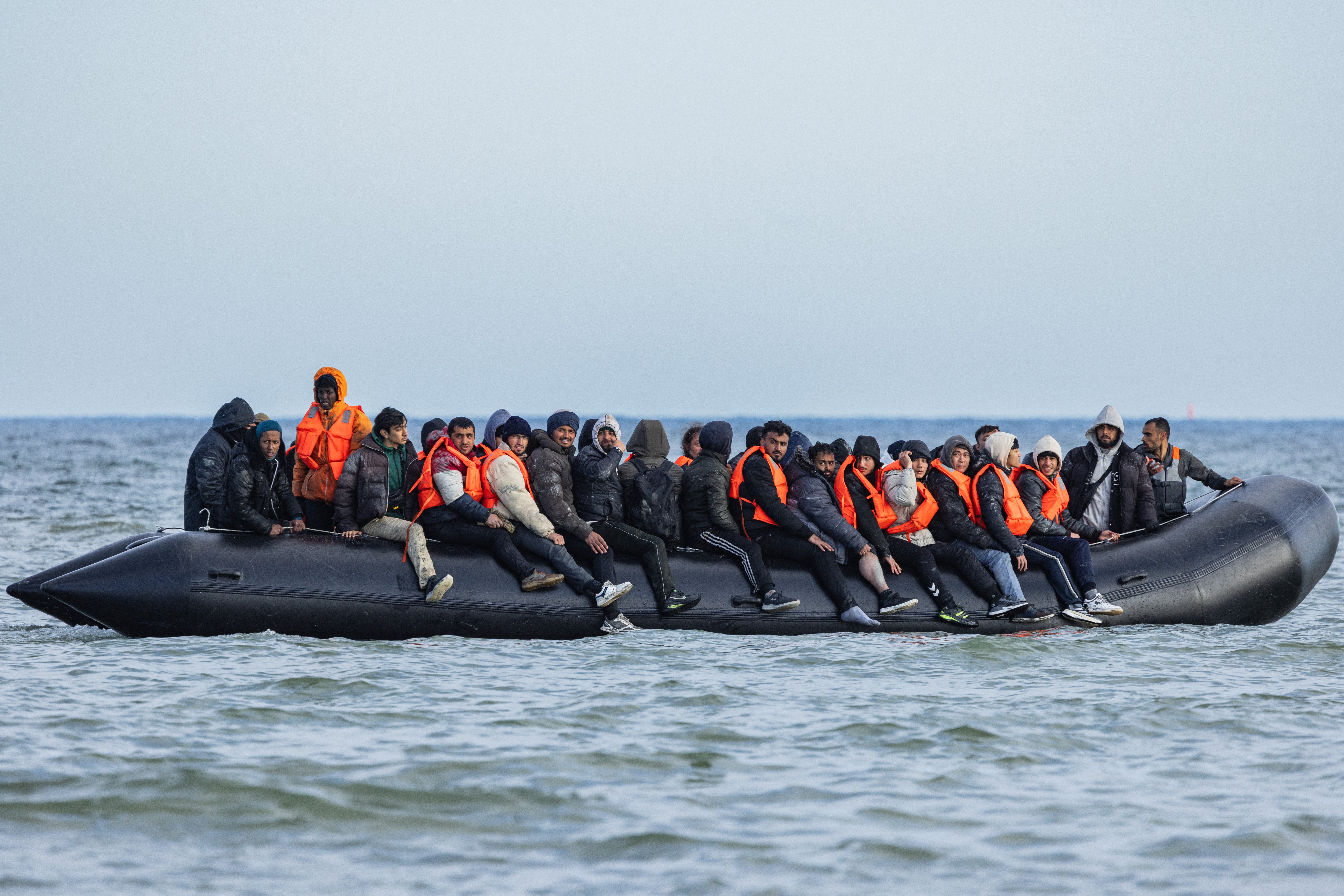 Migrants board a smugglers’ boat in an attempt to cross the English Channel, off the beach of Gravelines, northern France, on 26 March