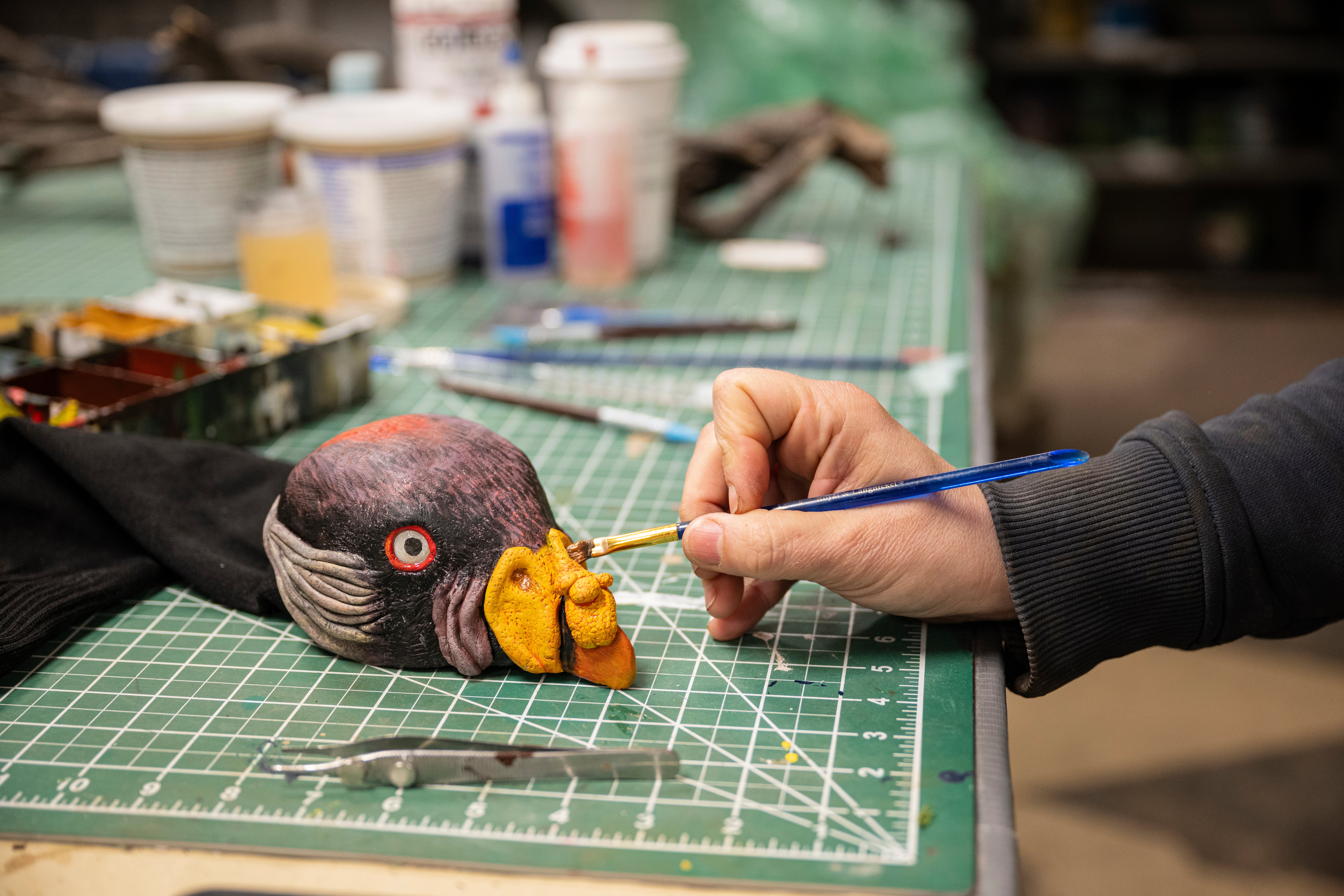 EGAD Manager Carolyn Fuchs paints details on a king vulture hand puppet
