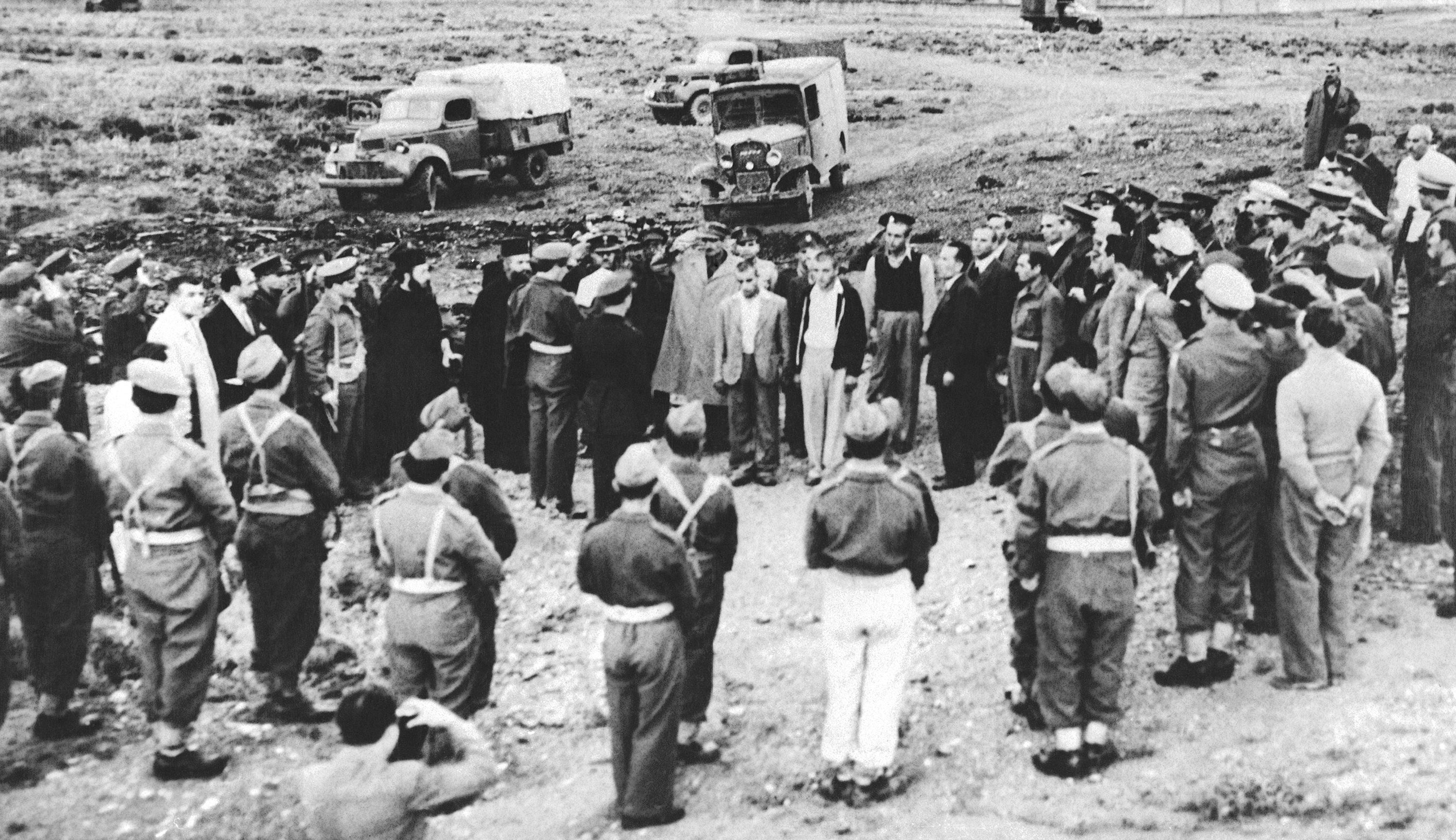 An officer reads execution orders to four condemned youths at a military installation near Athens, Greece, Oct. 29, 1947, as members of a firing squad stand with their backs to the camera. The youths, all from Peristeri, an Athens suburb, were convicted of aiding a Communist rebellion, conspiracy and a slaying. (AP Photo, File)