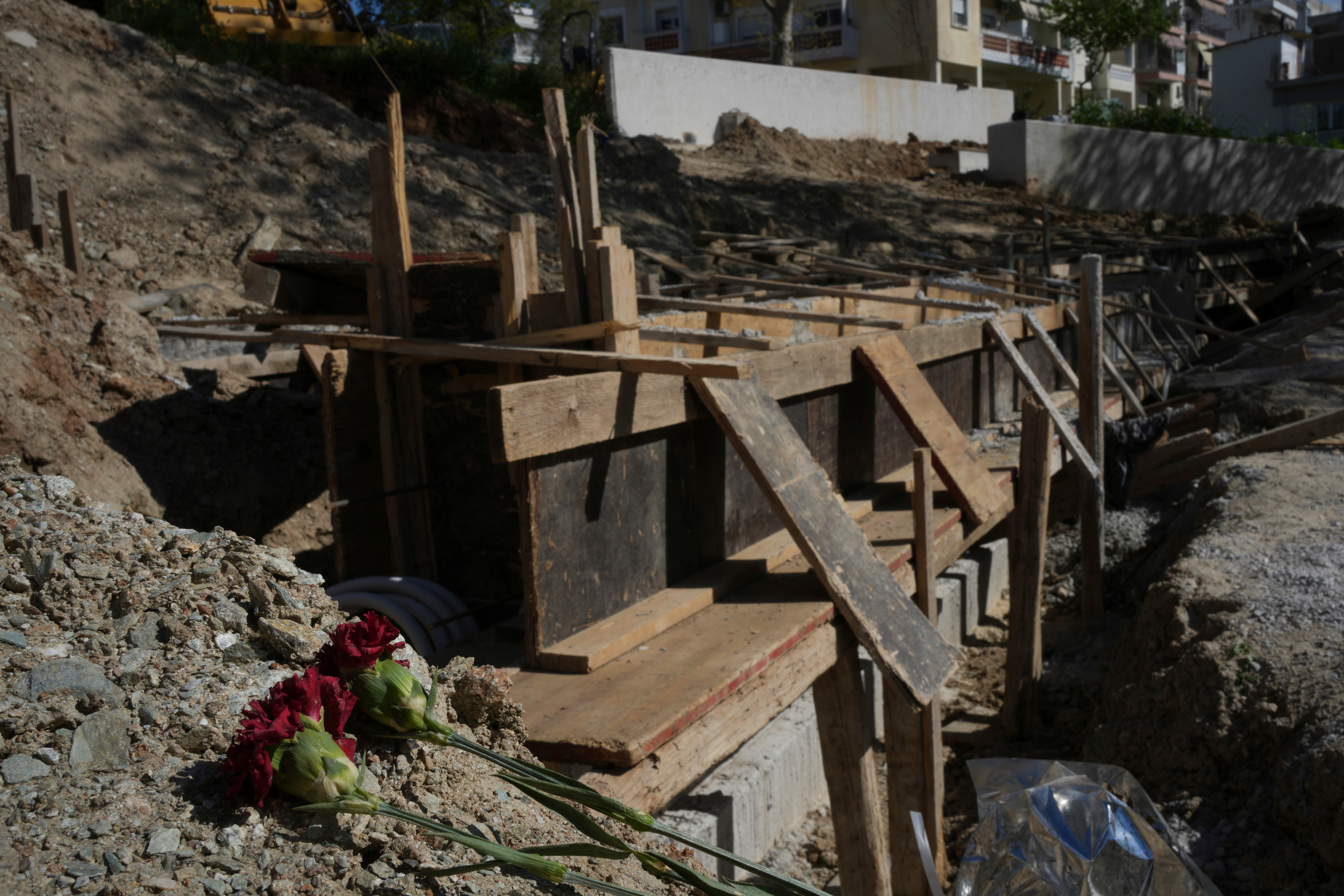 Flowers lie at the site where mass graves containing remains believed to have belonged to dozens of prisoners executed during or after the Greek Civil War were uncovered in Thessaloniki, Greece, Friday, April 11, 2025. (AP Photo/Thanassis Stavrakis)