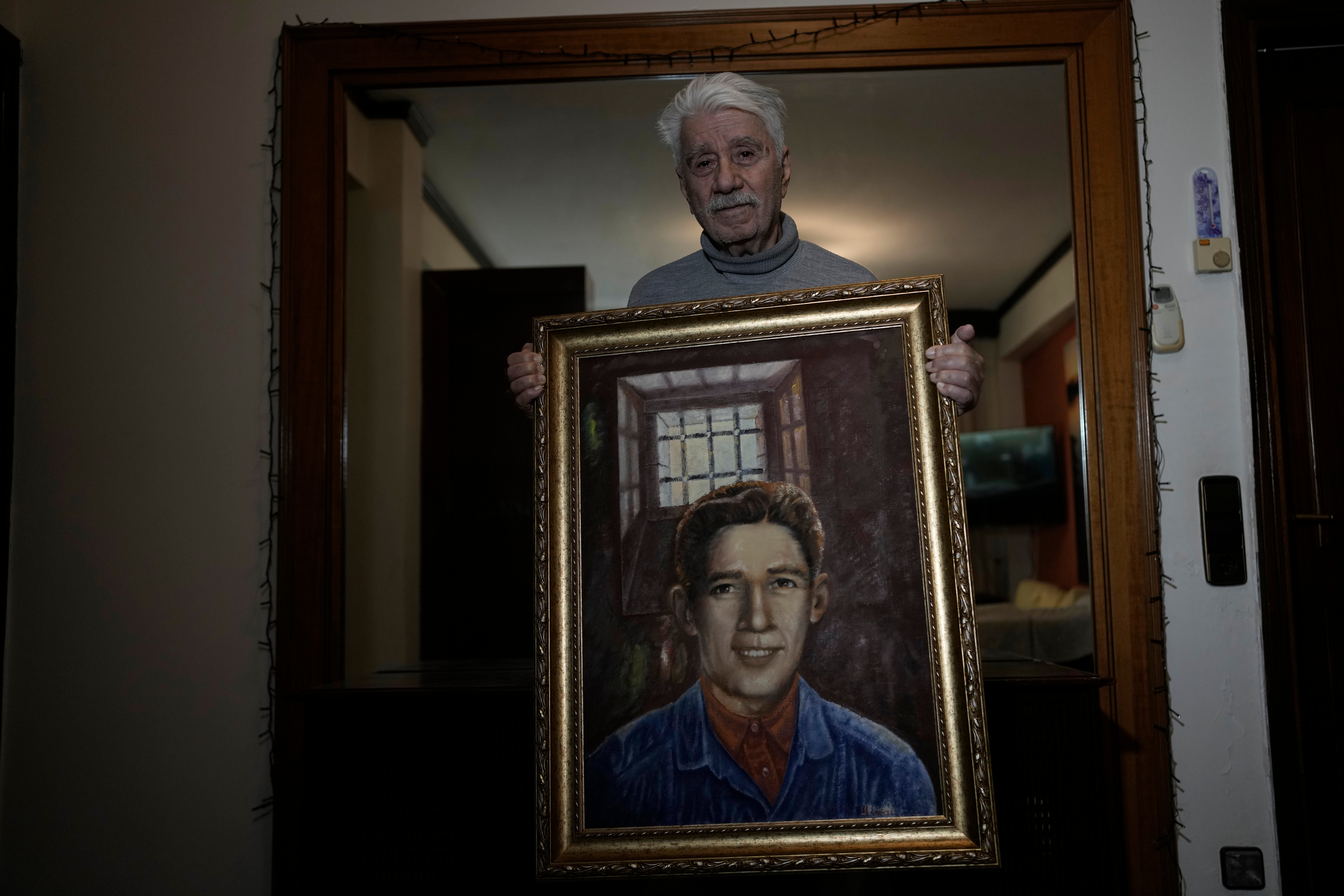 Agapios Sachinis holds a portrait of his uncle, a prisoner executed in the Greek Civil War, in Thessaloniki, Greece, on Saturday, April 12, 2025. (AP Photo/Thanassis Stavrakis)