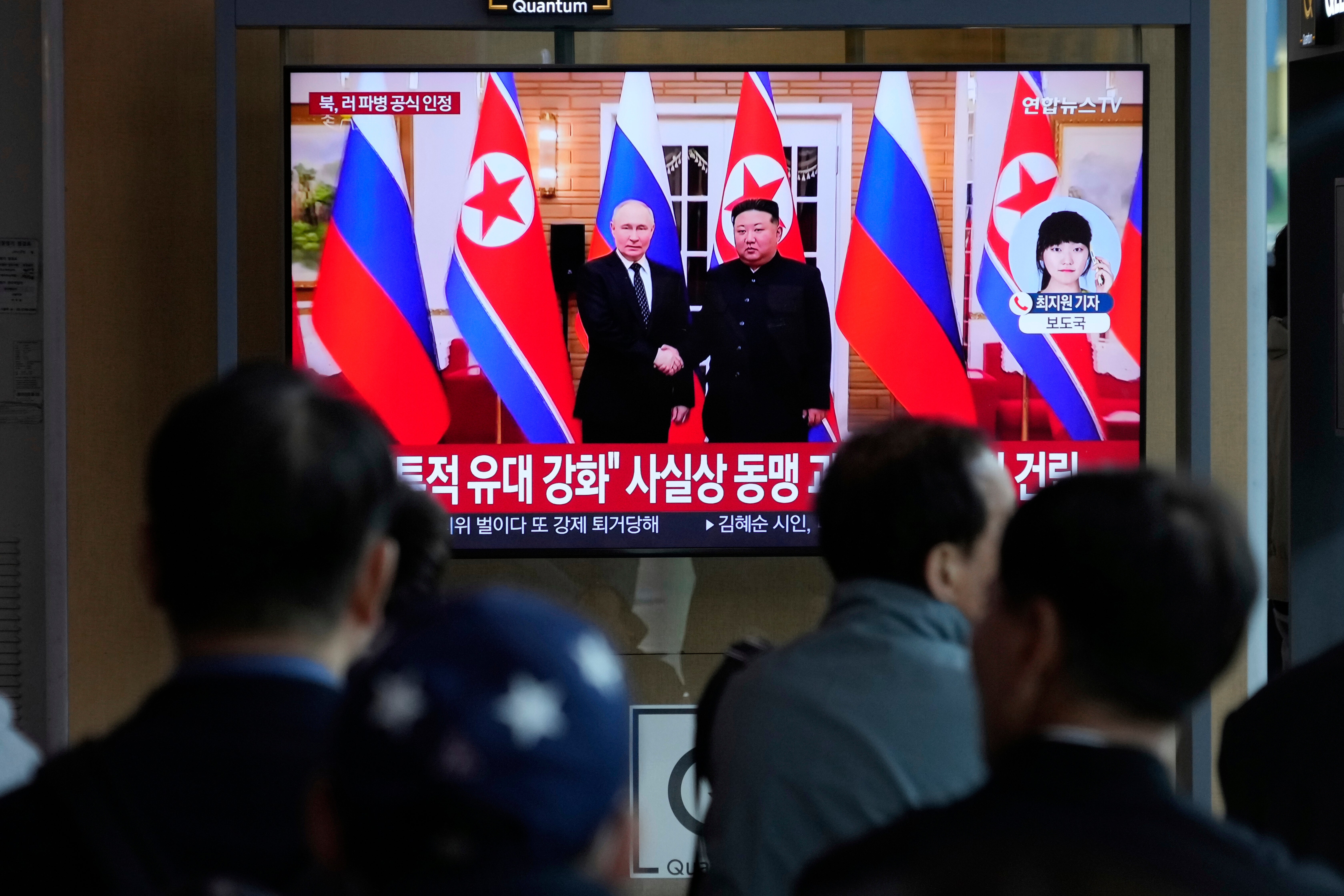 A TV screen shows North Korean leader Kim Jong Un with Russian president Vladimir Putin in Pyongyang