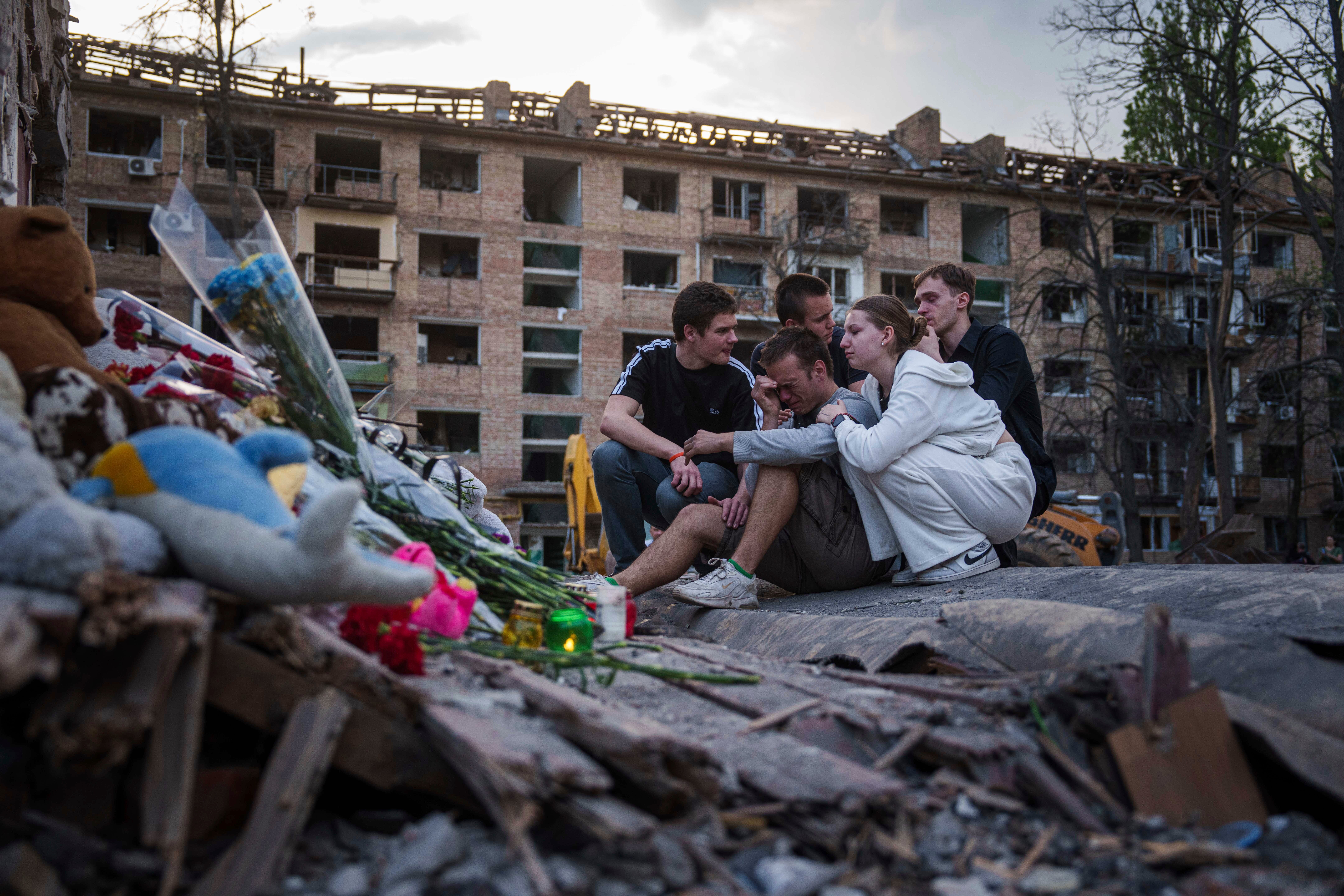 Friends of Danylo Khudia, 17, who was killed on Thursday by a Russian strike, gather near the rubble of a house in a residential neighborhood in Kyiv, Ukraine, on Friday, April 25, 2025. (AP Photo/Evgeniy Maloletka, File)