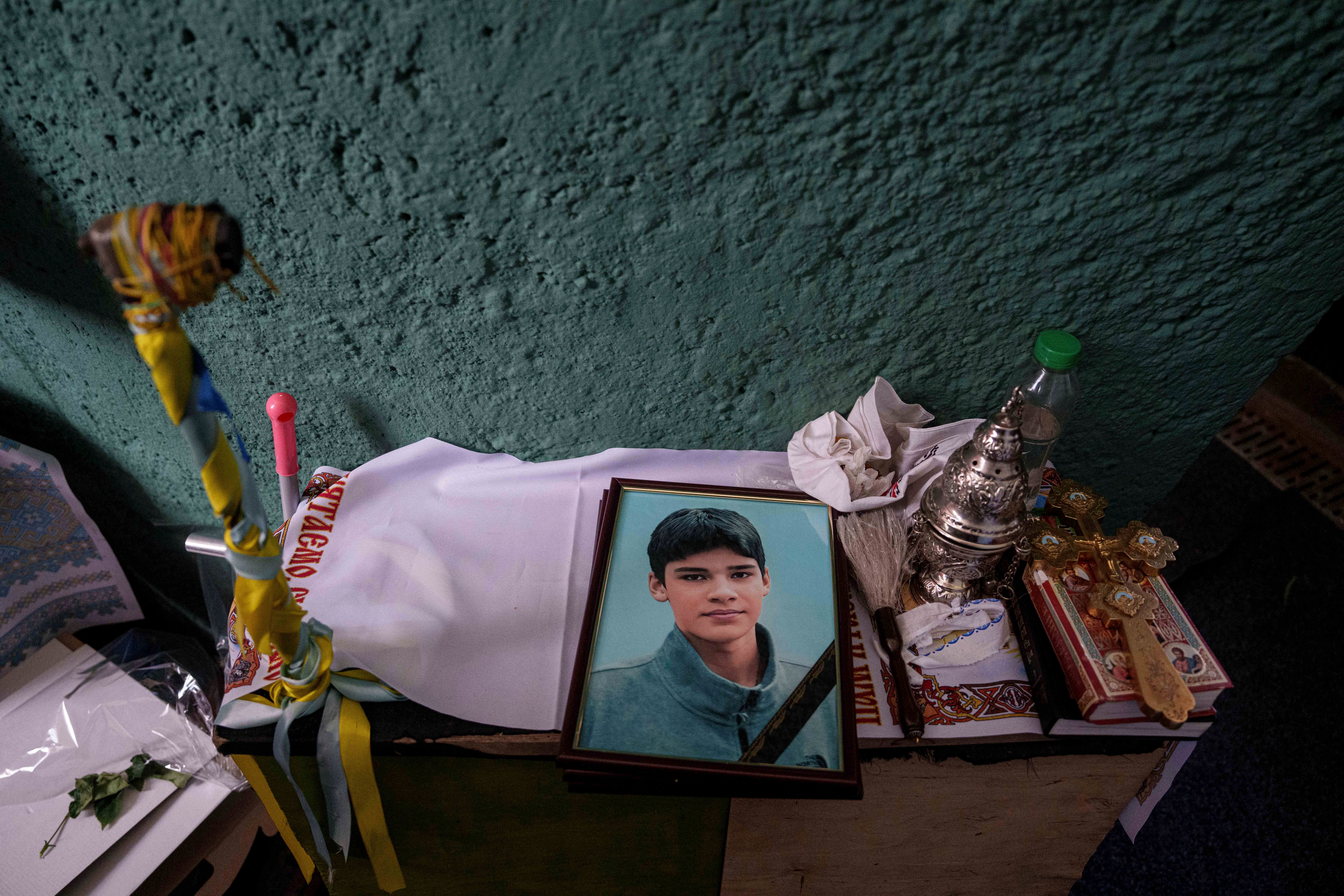 A photo of Danylo Khudia, 17, killed in a Russian strike along with his parents, Viktoria and Oleh Khudia on April 24, on a table during a farewell ceremony at the crematorium in Kyiv, Ukraine, on Monday, April 28, 2025. (AP Photo/Evgeniy Maloletka, File)