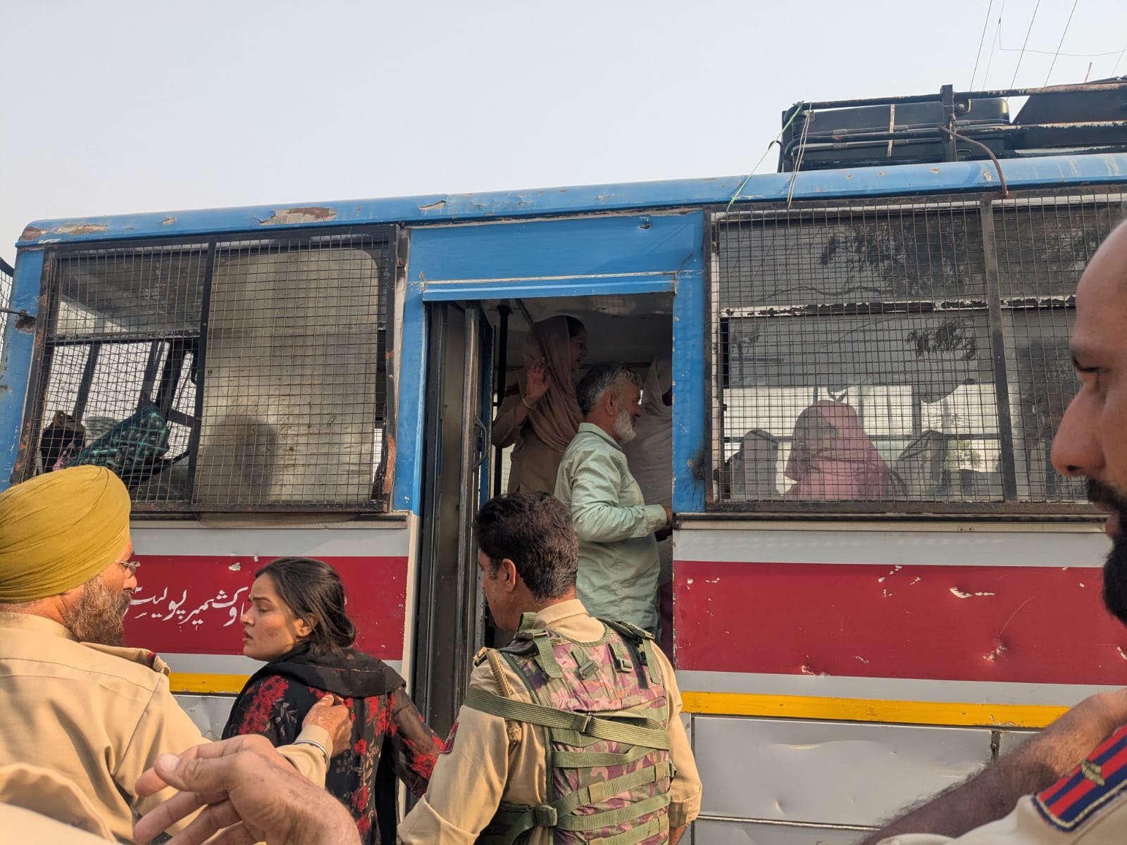 An Indian man checks with his Pakistani wife of 40 years before she takes a bus across the border