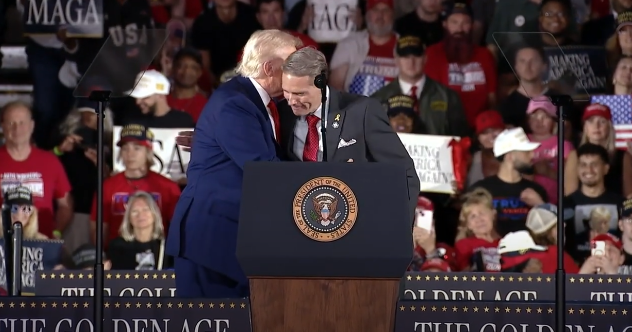 CNN senior political commentator Scott Jennings embraces President Donald Trump after being called on stage to address the crowd at the president's rally in Michigan.