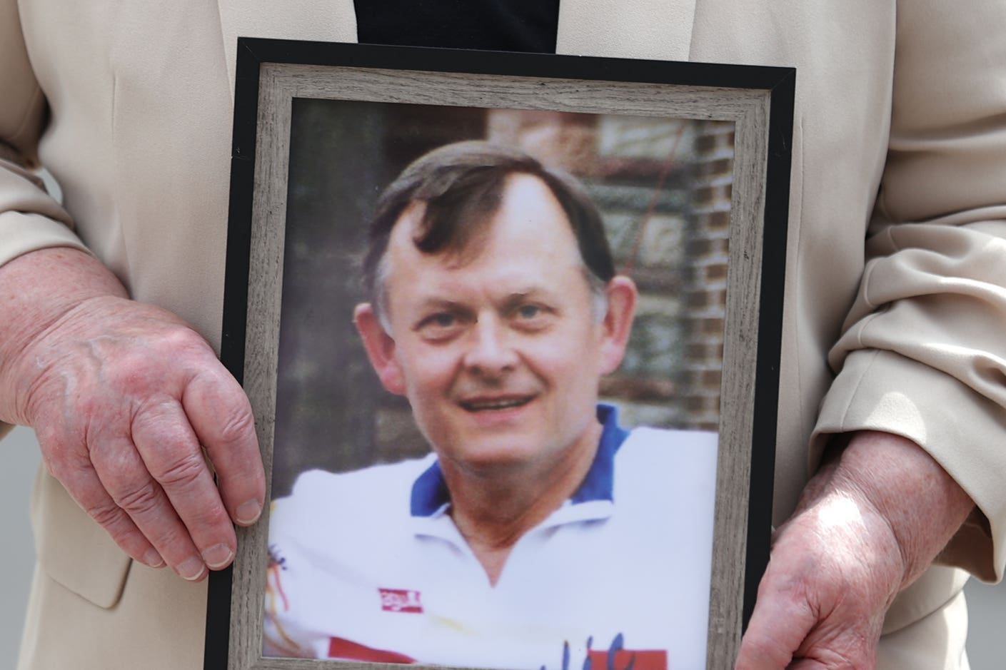 Bridie Brown, the widow of murdered GAA official Sean Brown, holds a picture of him, outside the Royal Courts of Justice in Belfast (PA)