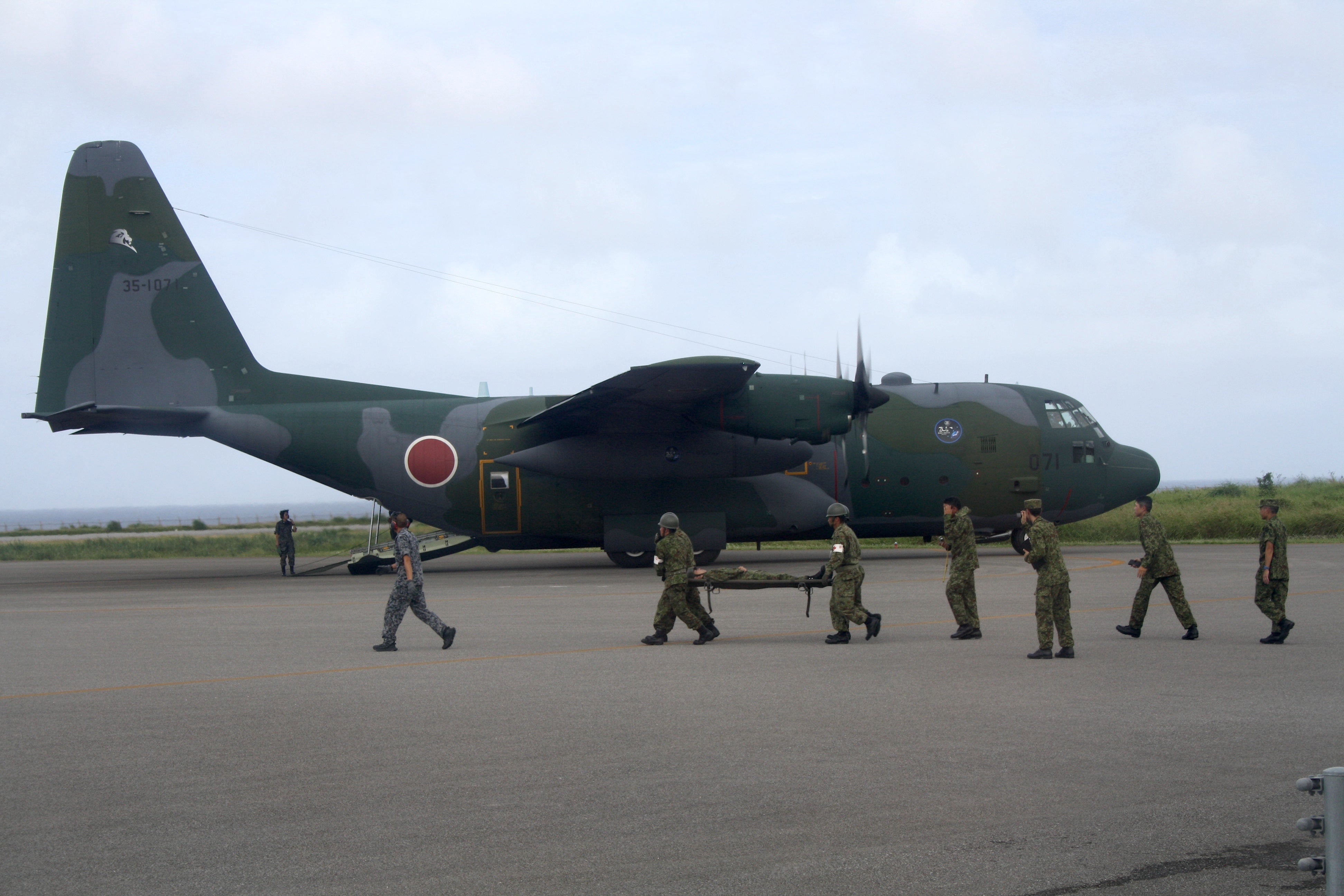 A Japanese soldier pretending to be a wounded islander is carried to a waiting American-made C-130 Hercules military transport plane as part of annual Keen Sword drills