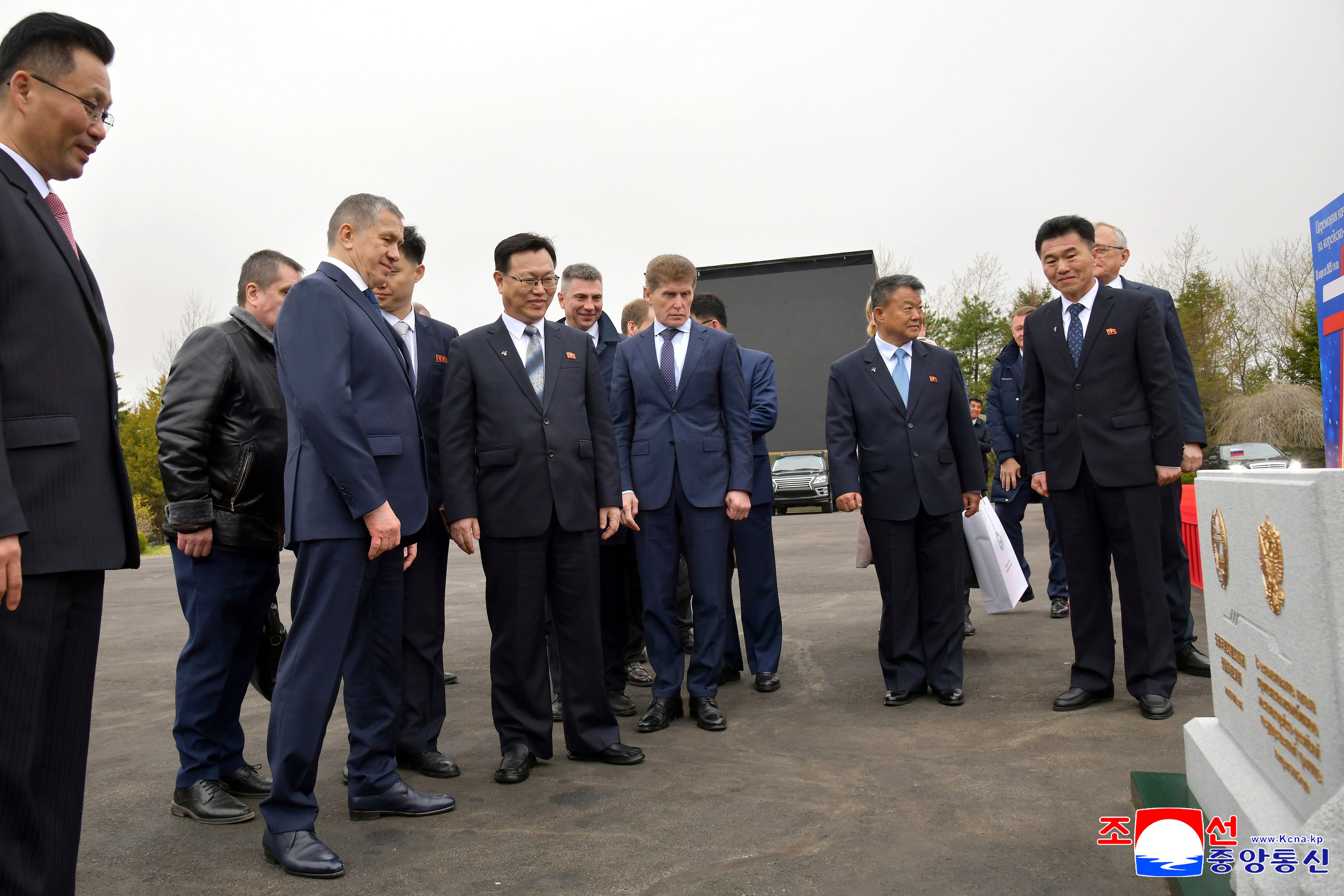 In this photo provided by the North Korean government, officials from North Korean and Russia stand in front of a monument to mark a ground-breaking ceremony for the construction of a bridge between the two countries, in Rason Municipality, North Kora Wednesday, April 30, 2025