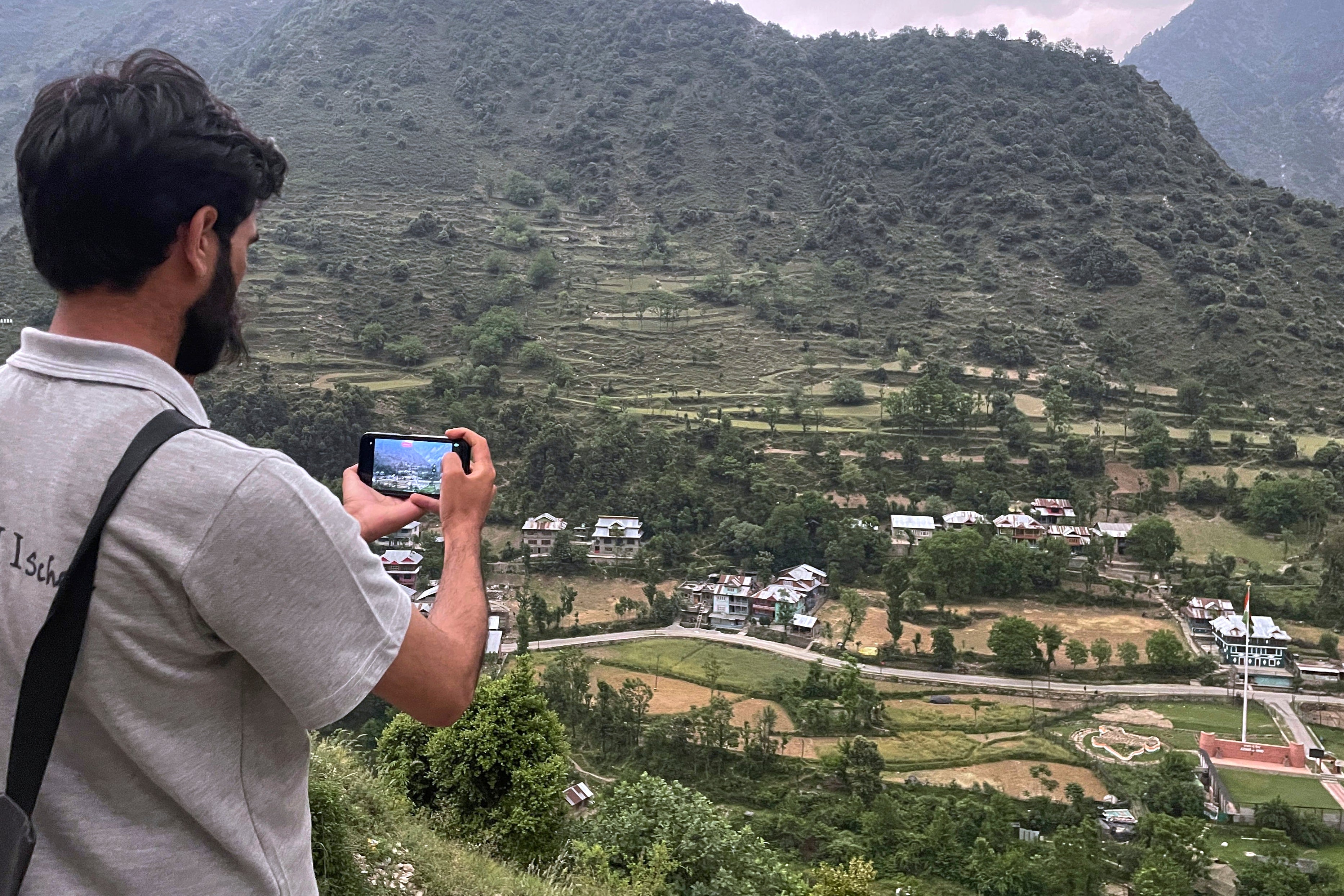 A man takes photos near the Line of Control