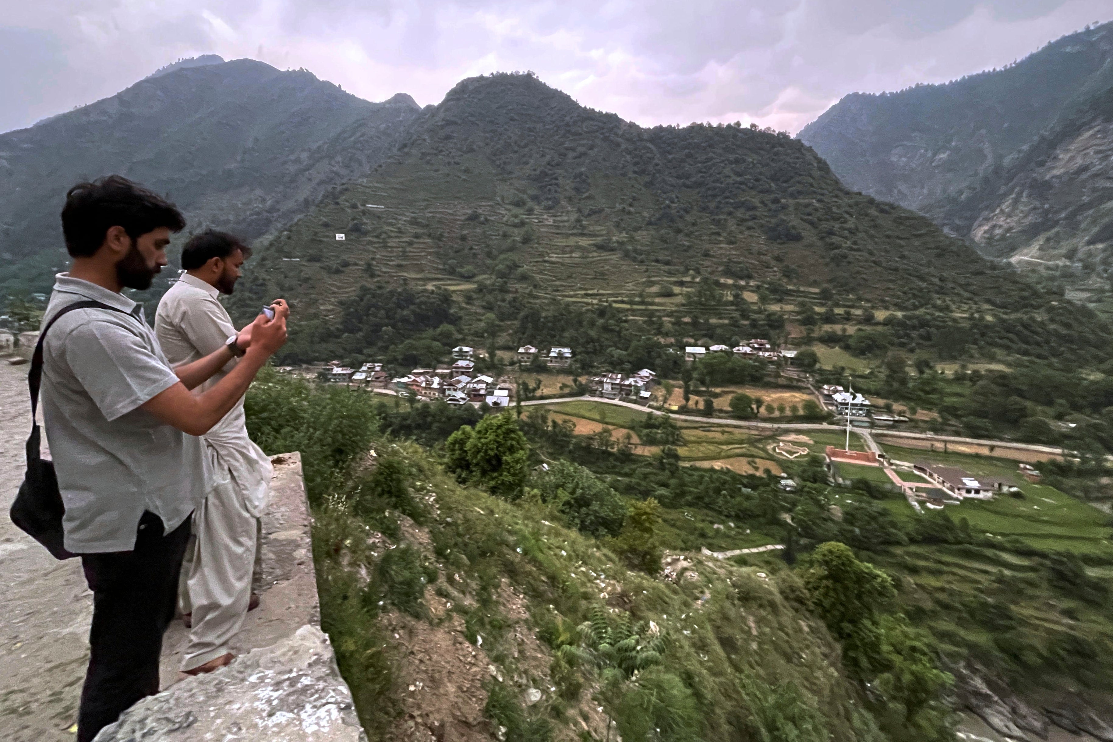 Local residents take picture with their mobile phones of Indian side Kashmir, at a view point from Pakistan side on the Line of Control, the de facto border dividing Pakistan and Indian Kashmir, in Chilhana, some 45 kilometres (27 miles) from Muzaffarabad, the capital of Pakistan controlled Kashmir, Thursday, May 1, 2025. (AP Photo/M.D. Mughal)