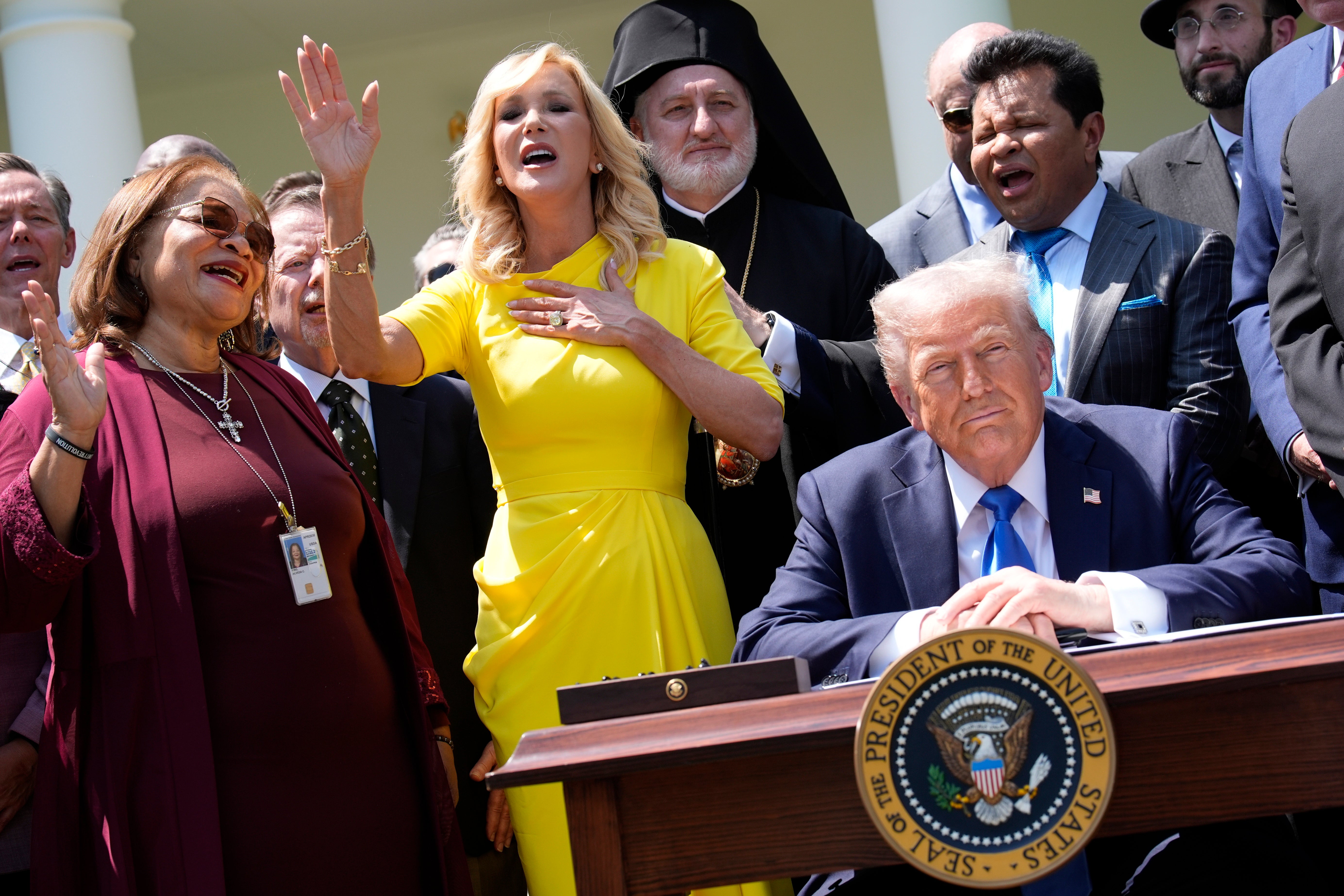 Trump listens to prayers by religious leaders, including Paula White, center, in the Rose Garden at the White House