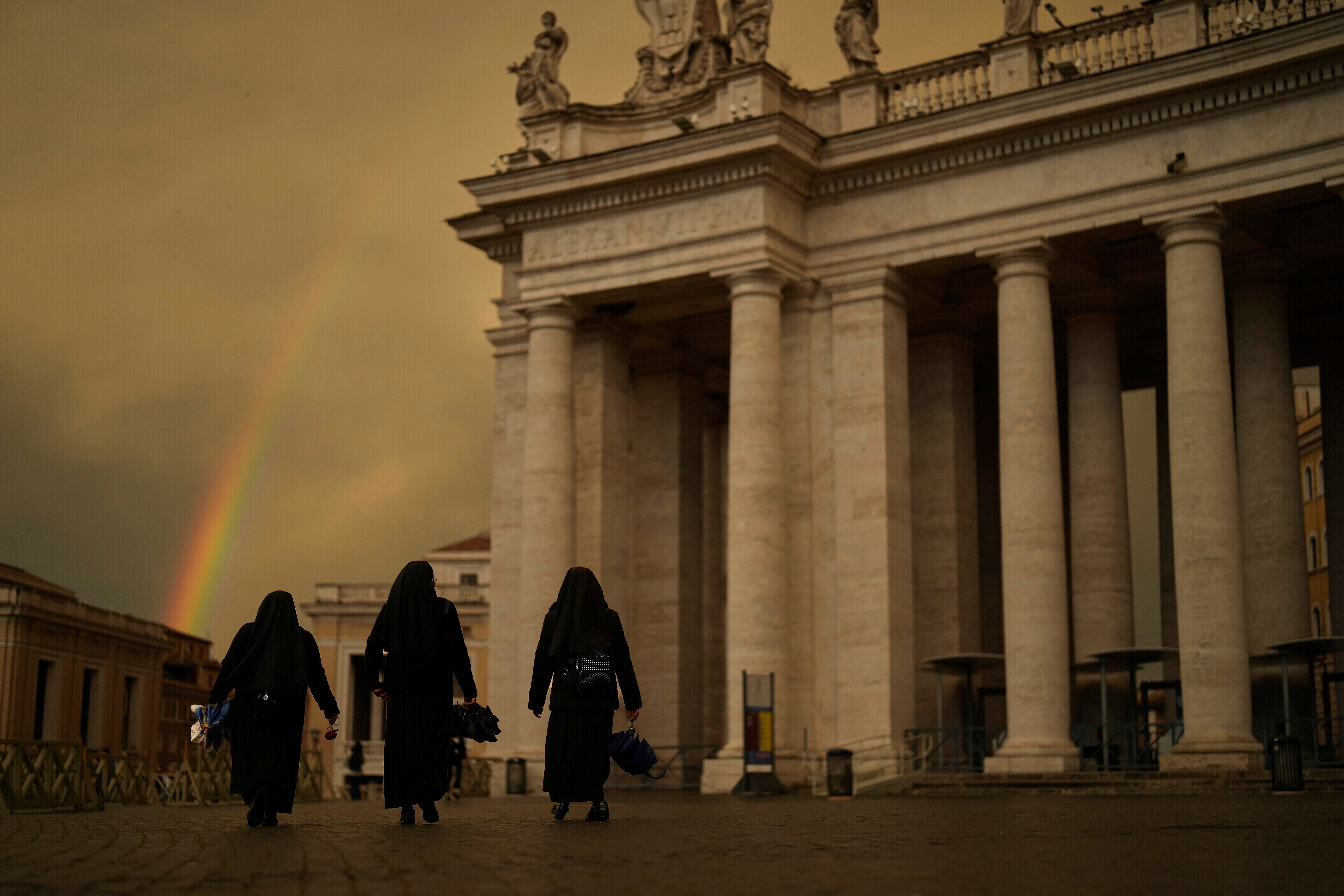 Nuns walk through St. Peter's Square where a rainbow appeared after a rain on the fourth of nine days of mourning for the late Pope Francis, at the Vatican, April 29, 2025. (AP Photo/Francisco Seco)
