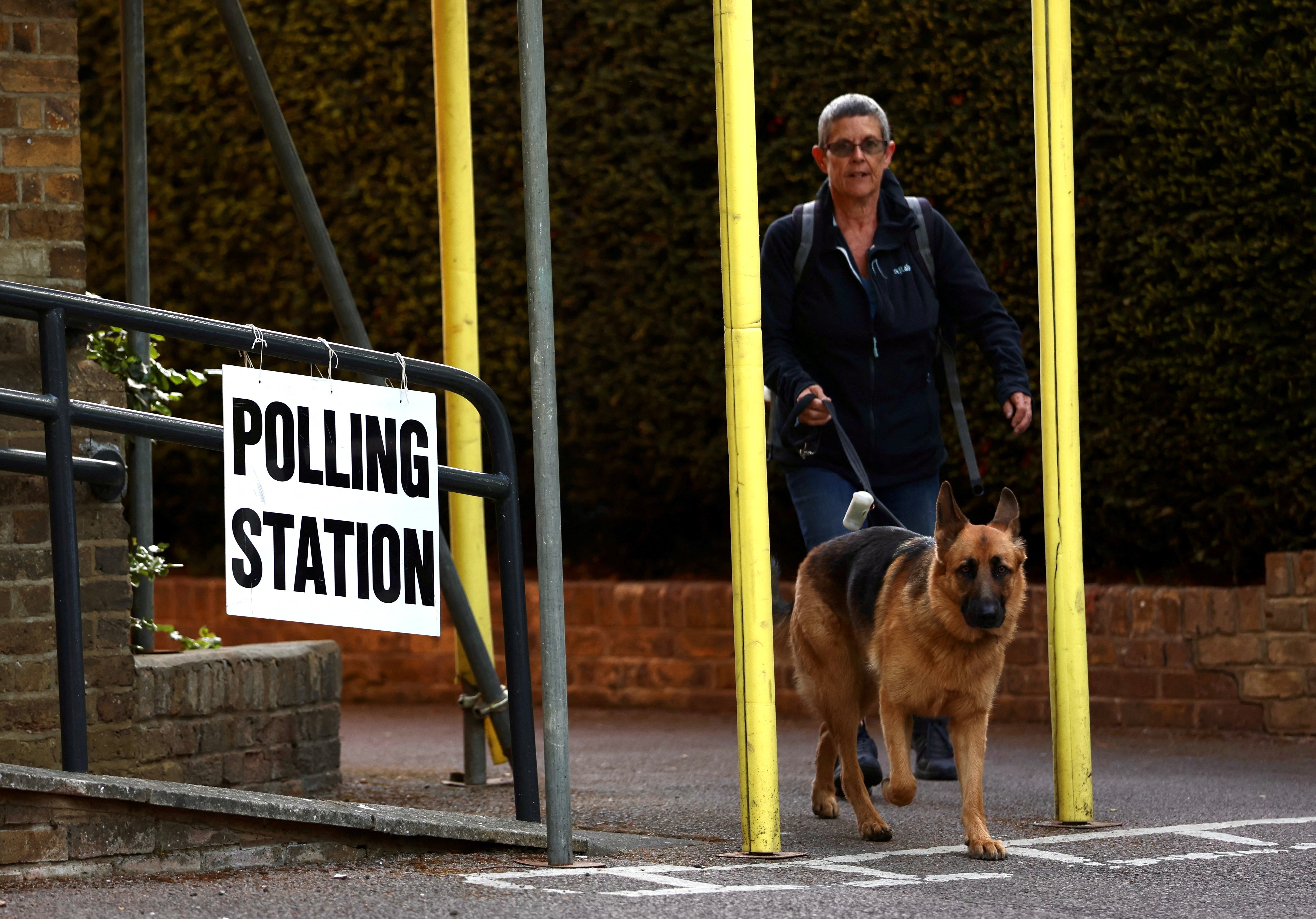 A woman and her dog leave a polling station in Rickmansworth