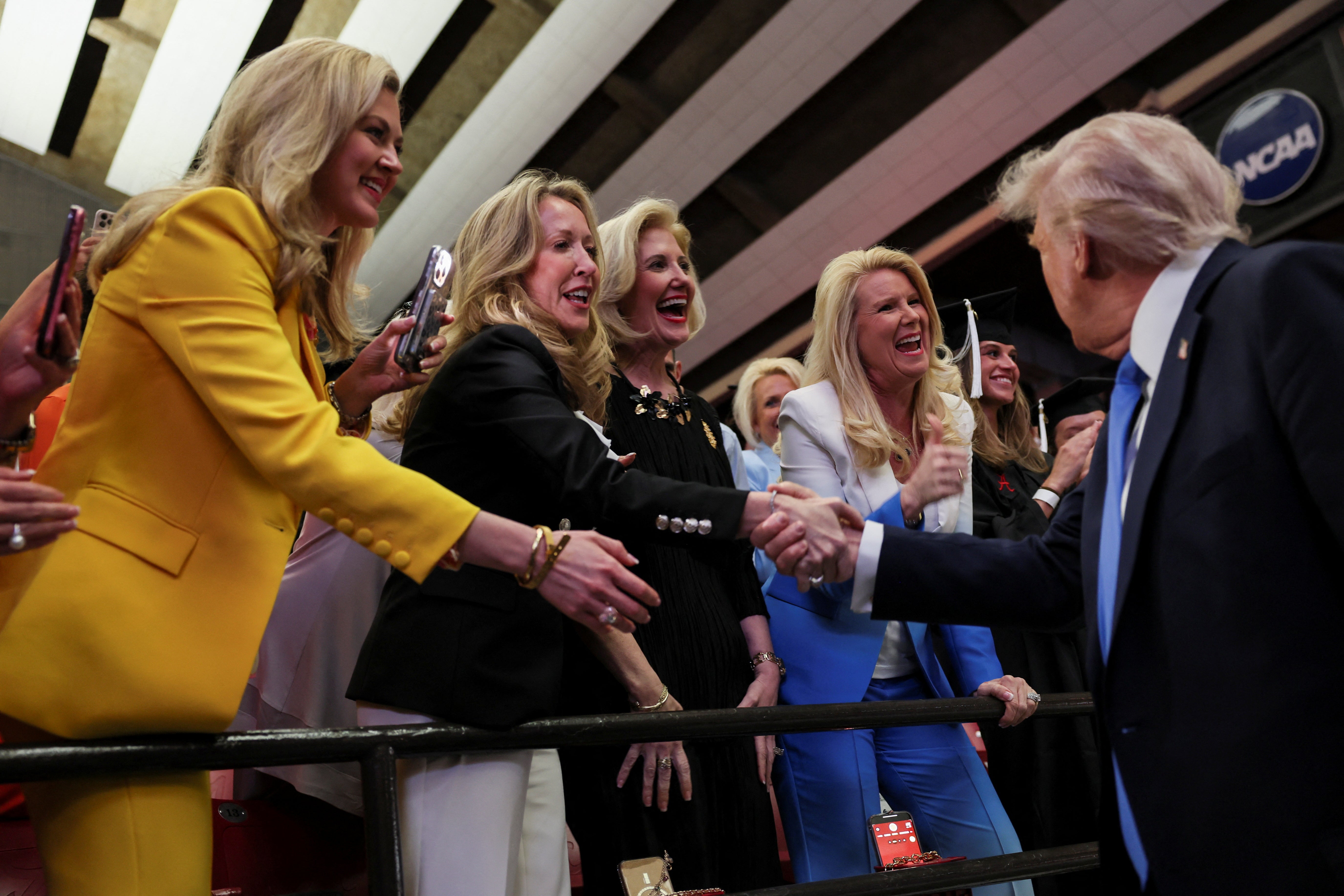 Trump shakes hands with supporters at the University of Alabama after speaking to the grads, where he mixed in political complaints with advice.