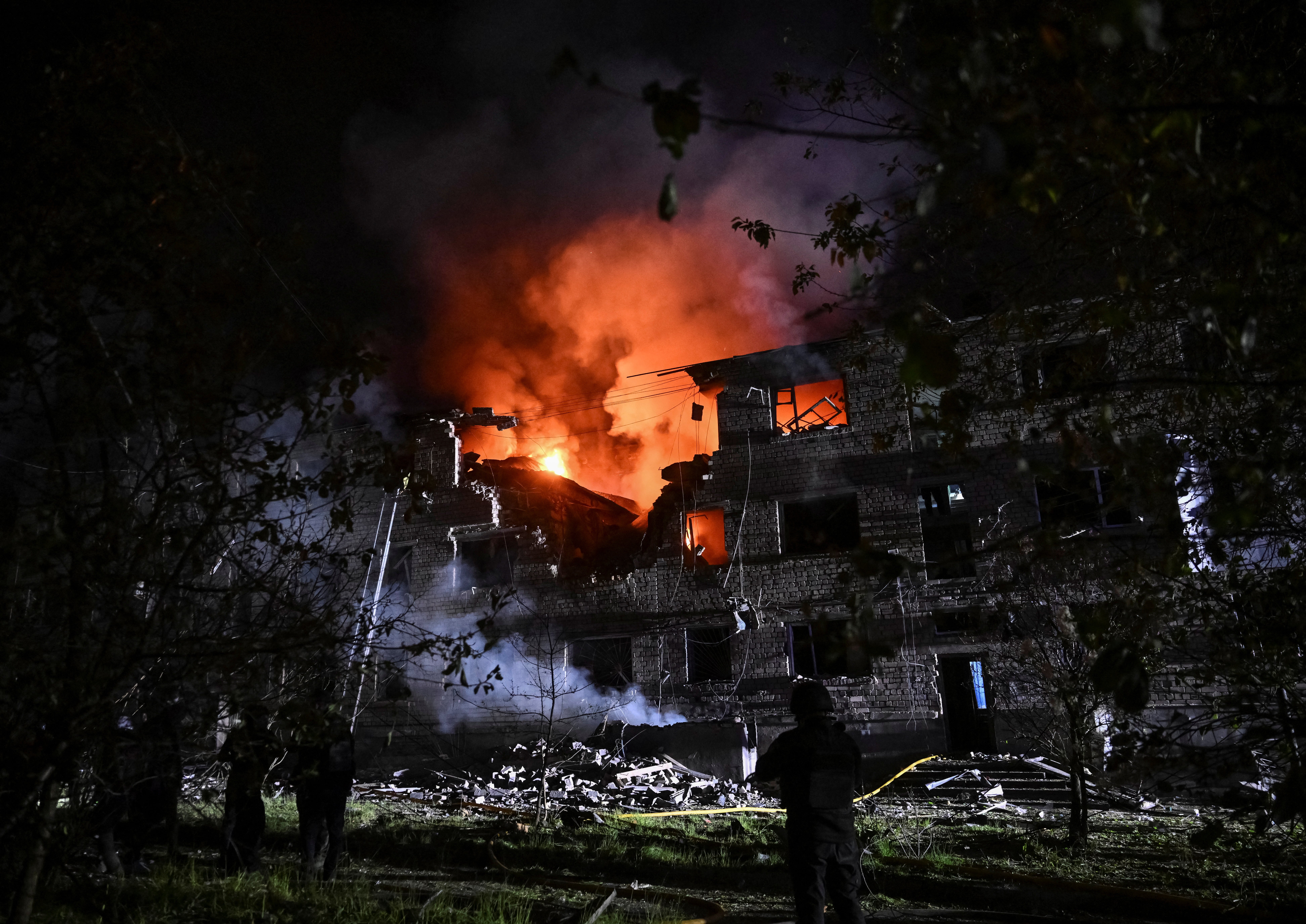 Rescuers work at an apartment building hit by a Russian drone on Friday in Ukraine's Zaporizhzhia